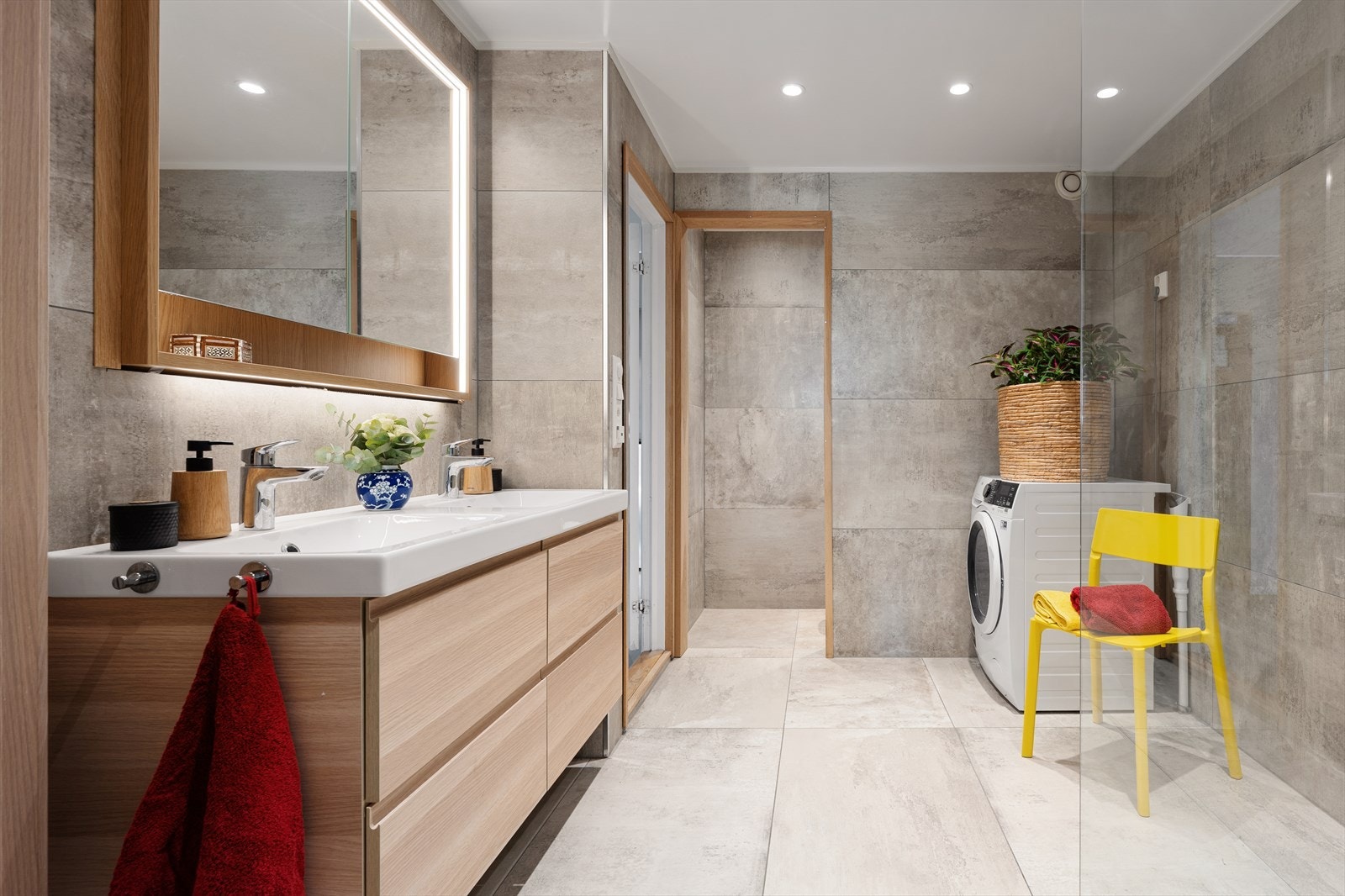 Badet er moderne og romslig med inngang til toalett gjennom åpningen. Opplegg til vaskemaskin og tørketrommel. Galleribilde