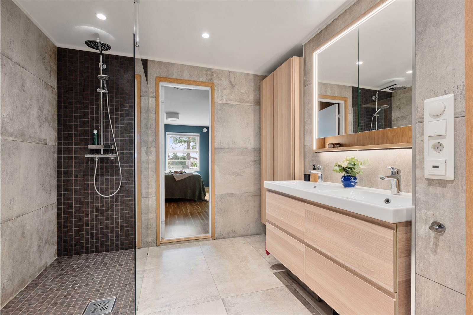 Lekkert og romslig bad fra 2017. Det er slått sammen to rom slik at badet har fått stor dusj og dobbelservant med oppbevaring og mye gulvplass. Galleribilde