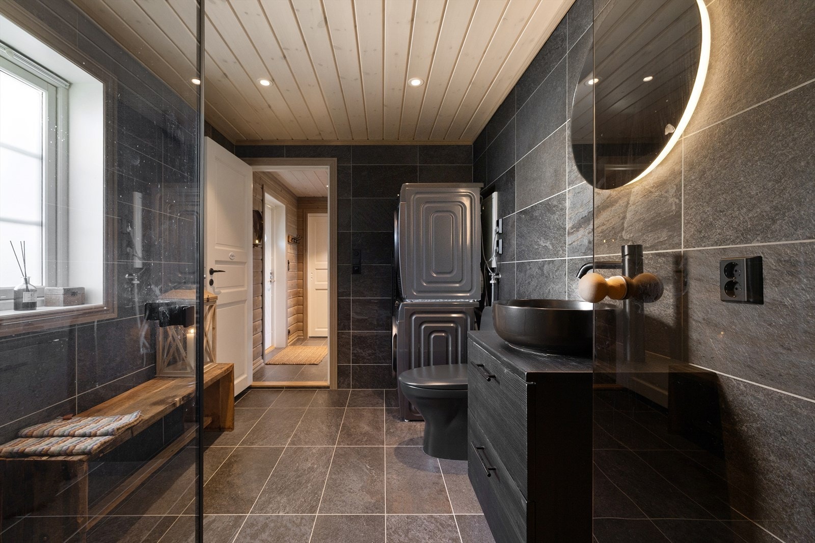 Badet og vaskerommet er kombinert i ett praktisk og moderne rom med gjennomgående gode materialvalg. Galleribilde