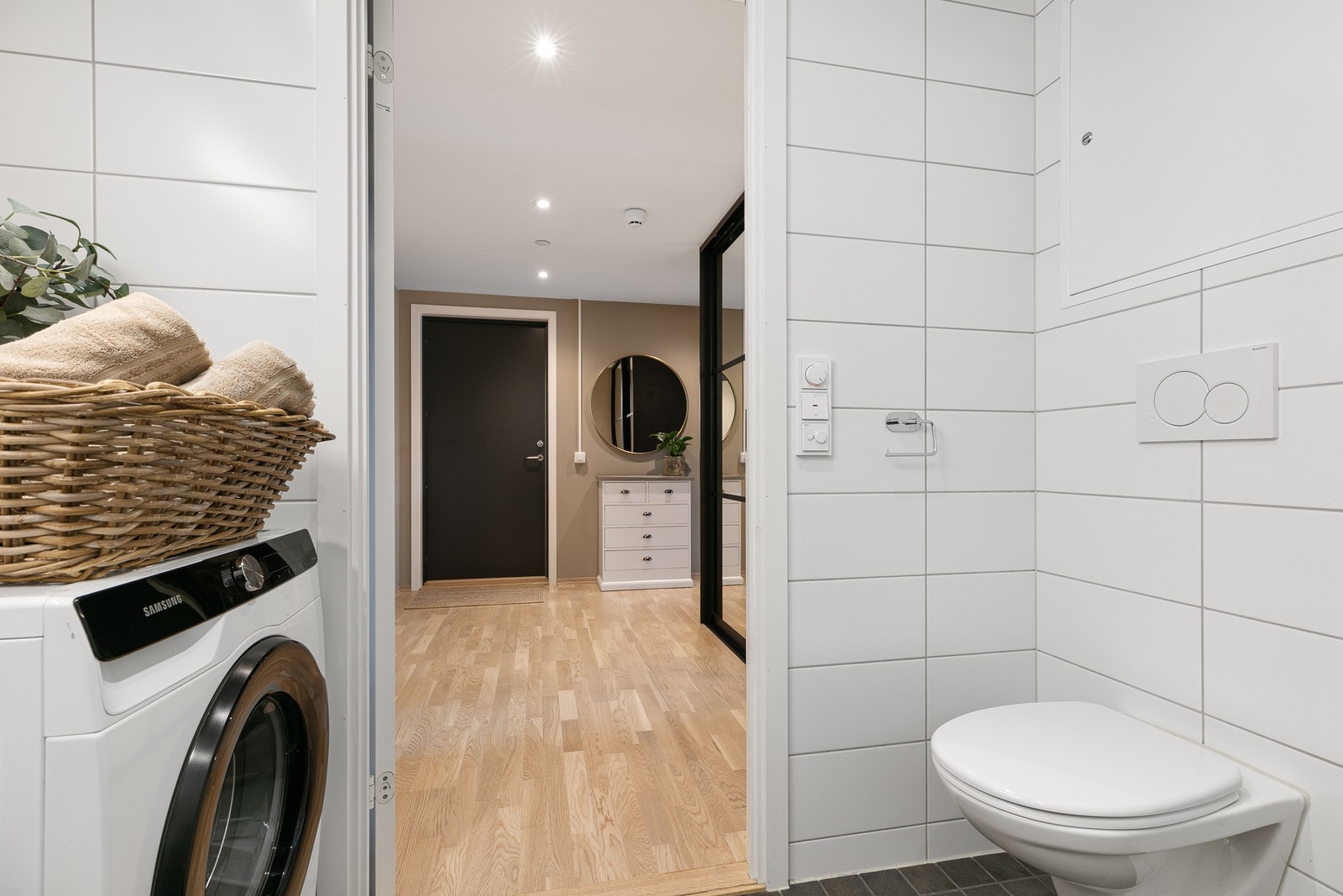 Det flislagte badet fra byggeår har varmekabler i gulv, toalett, servant, dusjsone og opplegg for vaskemaskin Galleribilde