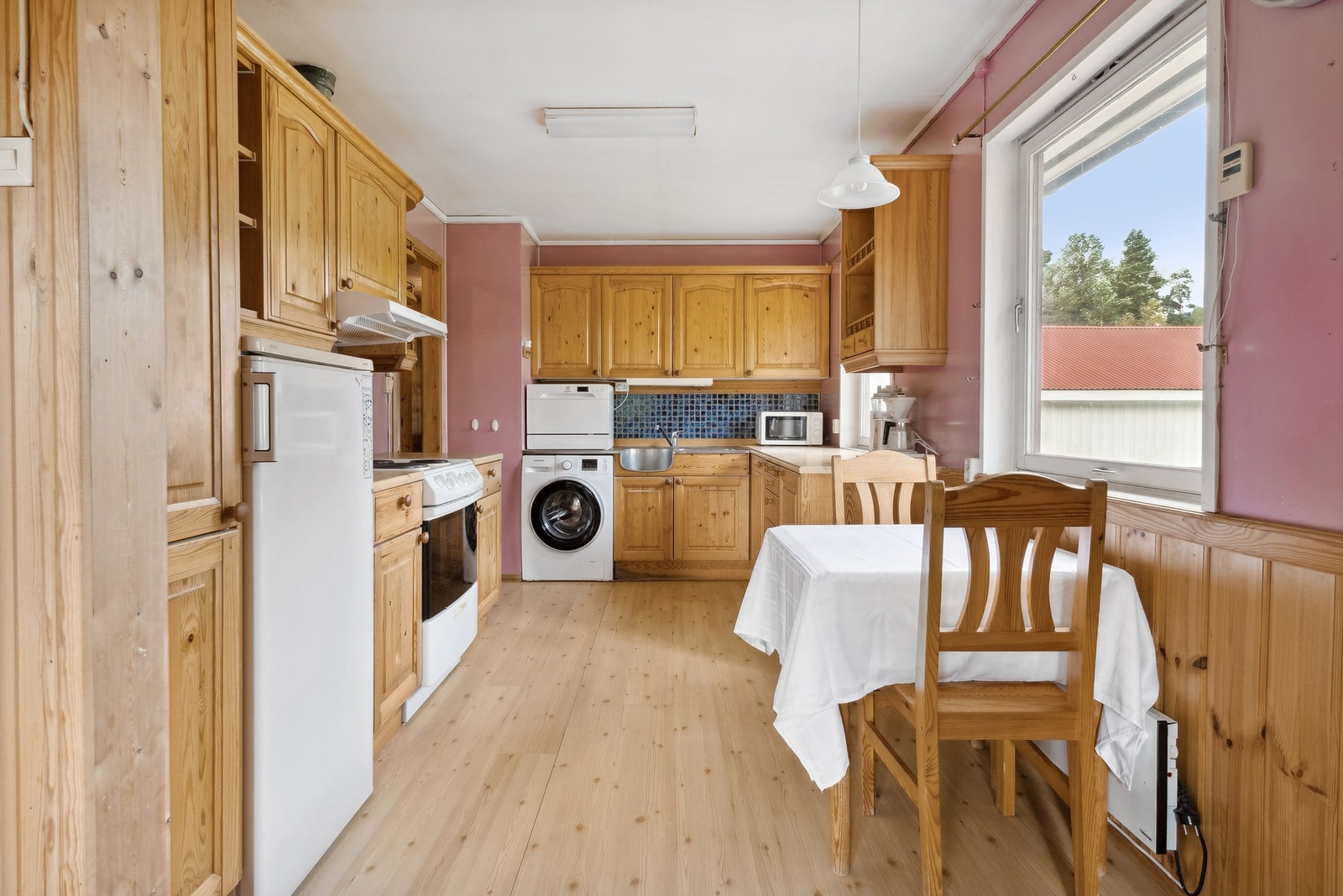 Bak vasken er det flislagt vegg. Det er opplegg for både benkeoppvaskmaskin og komfyr. Galleribilde