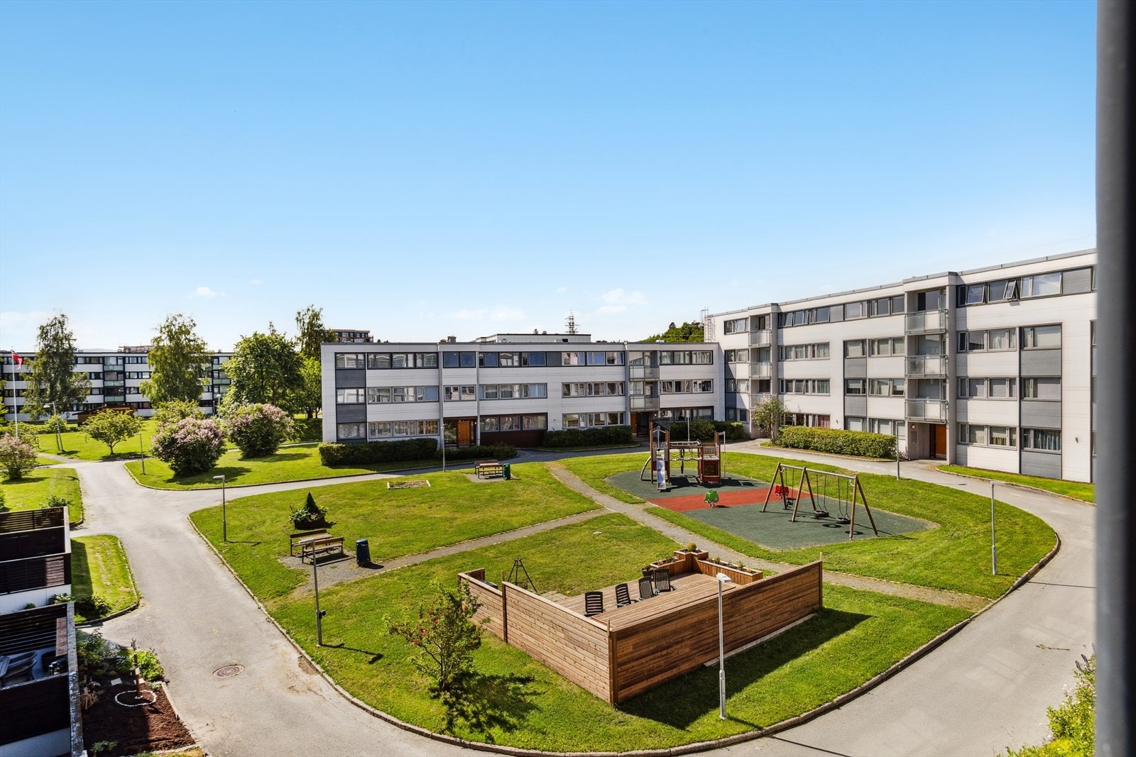 Pent opparbeidede grøntområder med benker, lekeapparater og felles grillområde. Galleribilde