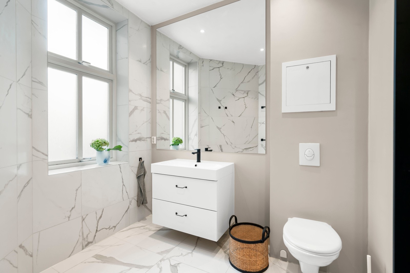 Rommet har delikate, store fliser som harmonerer med de sorte detaljene som går igjen på hele badet, og skaper et stilfullt og gjennomtenkt uttrykk. Galleribilde