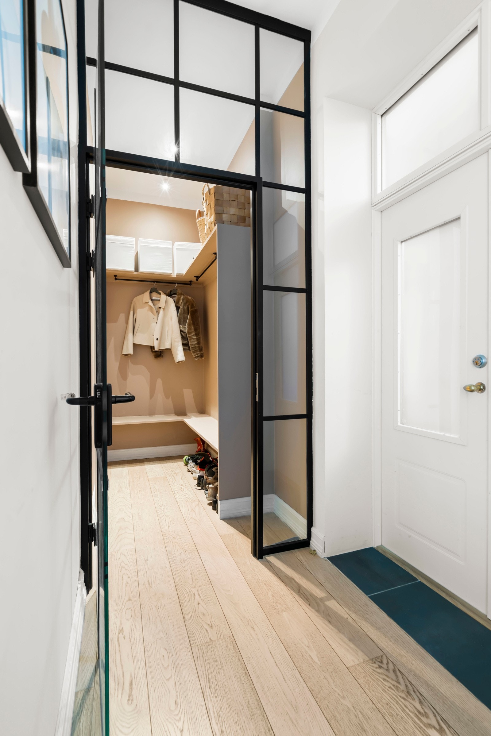 Pen garderobeløsning med god plass til å henge fra seg yttertøy og sette fra seg sko. Det er også mulighet for å lukke garderoben med spesiallagde smijernsdører, en praktisk løsning som bidrar til et ryddig uttrykk i entreen. Galleribilde