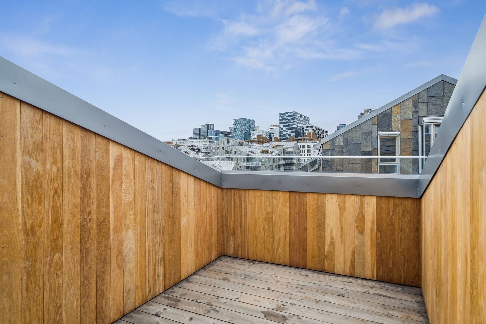 Privat balkong med trepaneler og panoramautsikt over nærområdet. Galleribilde