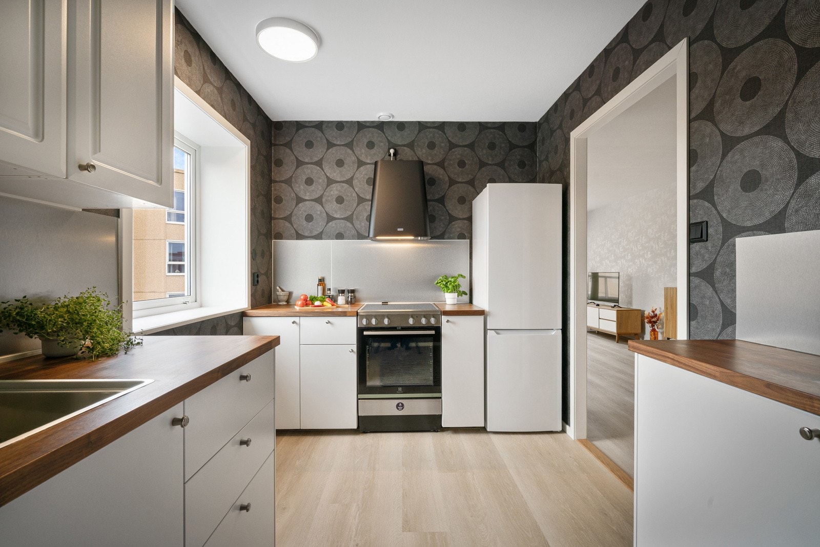 Kjøkkeninnredning med hvite fronter og benkeplate av valnøtt/finer Galleribilde