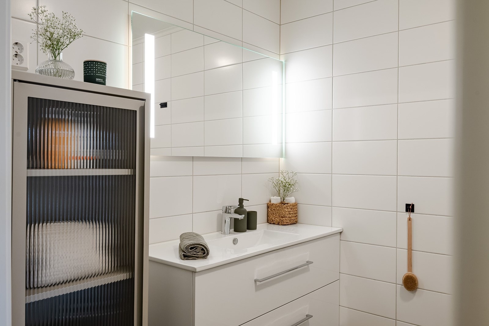 Baderommet har mørke fliser på gulv, deilig gulvvarme, hvite fliser på veggene og avtrekk via balansert ventilasjon. Galleribilde