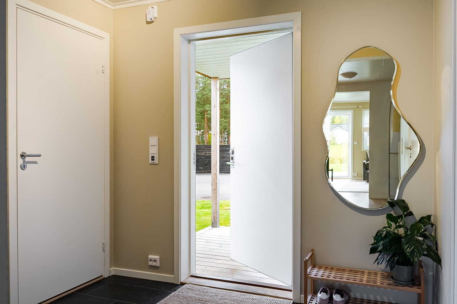 Når du entrer boligen, kommer du inn i en innbydende entré med plass til sko og oppheng av yttertøy. Her har du også enkel tilgang til et praktisk vaskerom med ytterligere lagringsmuligheter. Galleribilde