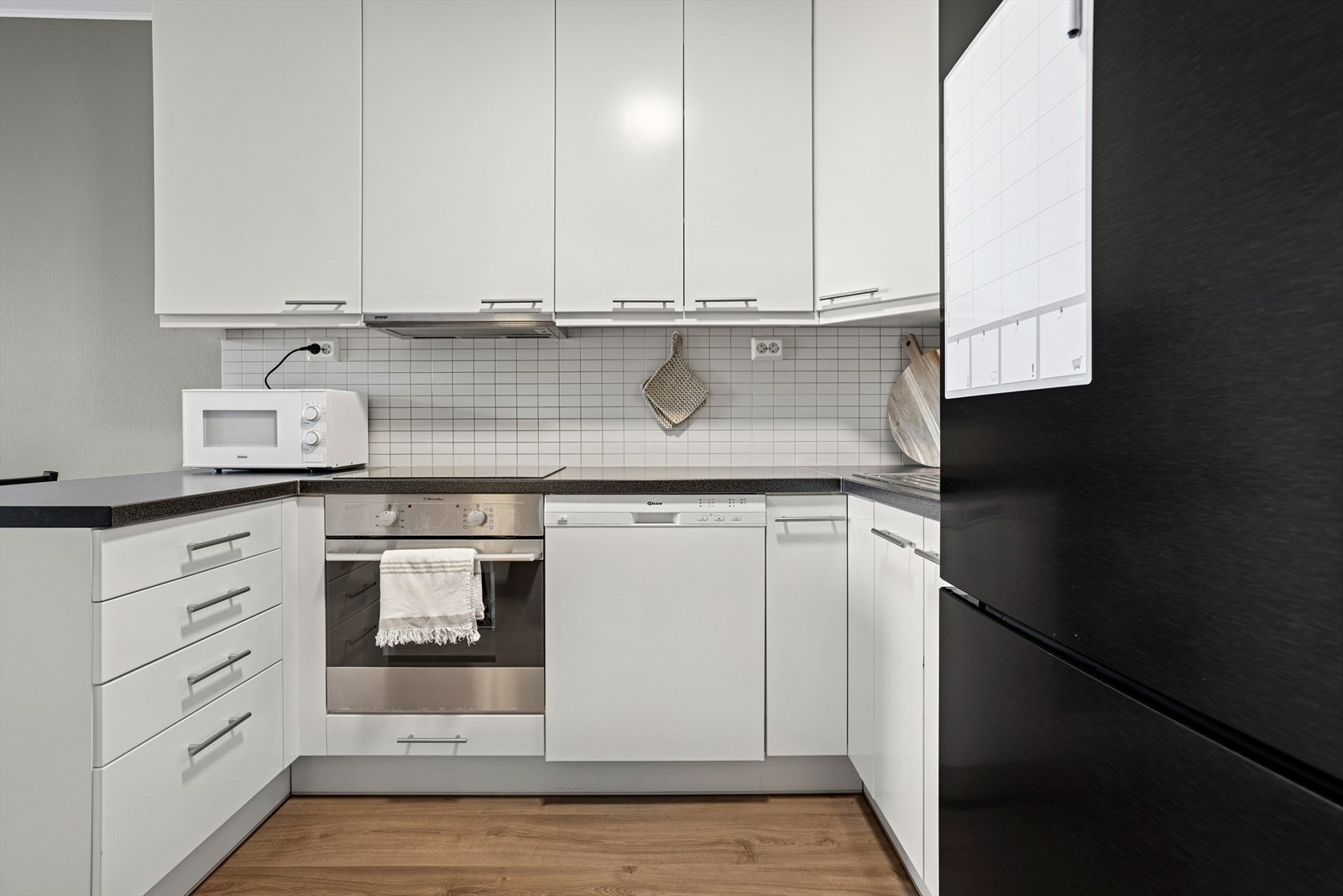 Kjøkkenet er innredet med lyse, glatte fronter. Galleribilde