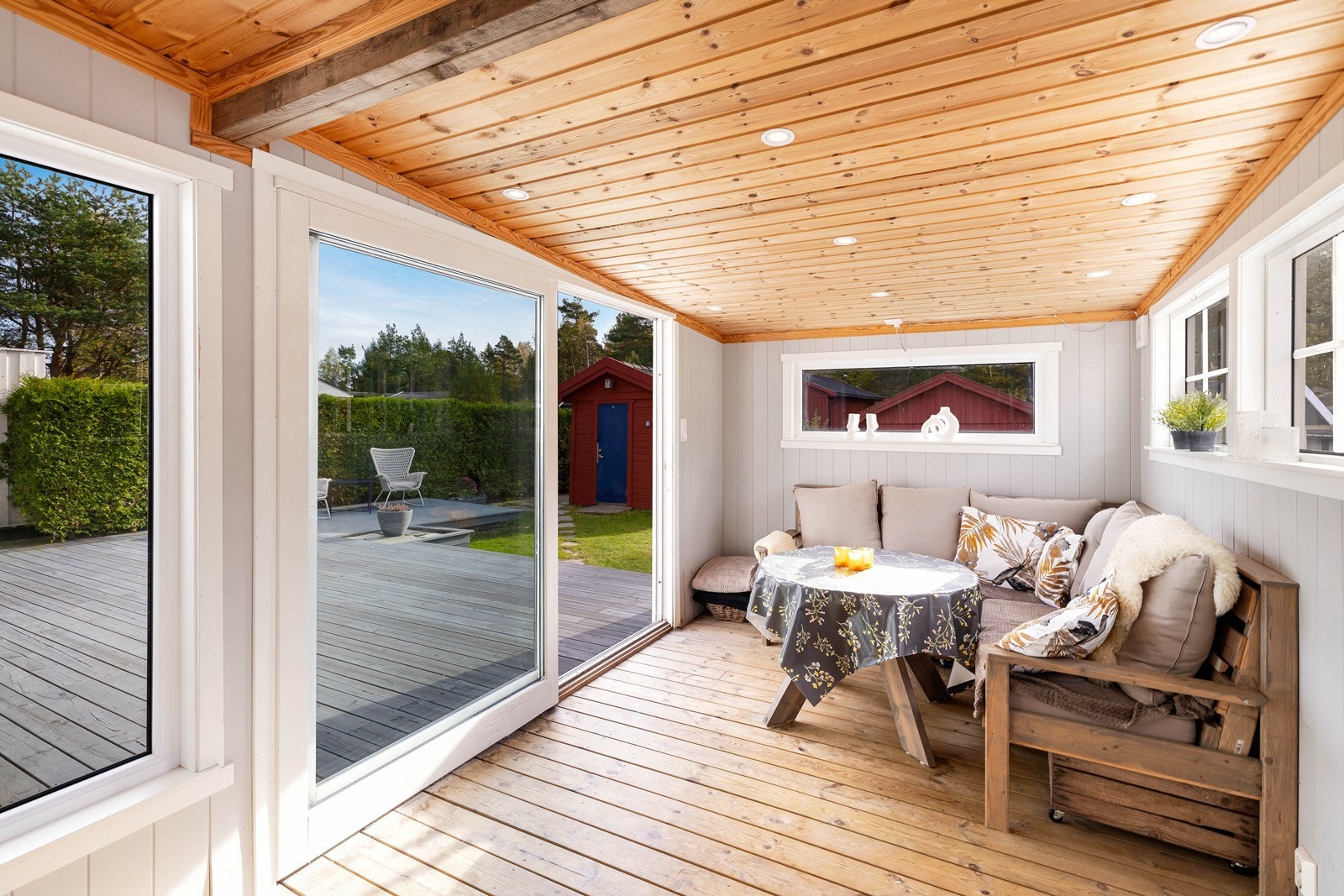 Livet utendørs nytes til fulle i en inngjerdet hage med sommerstue. Galleribilde