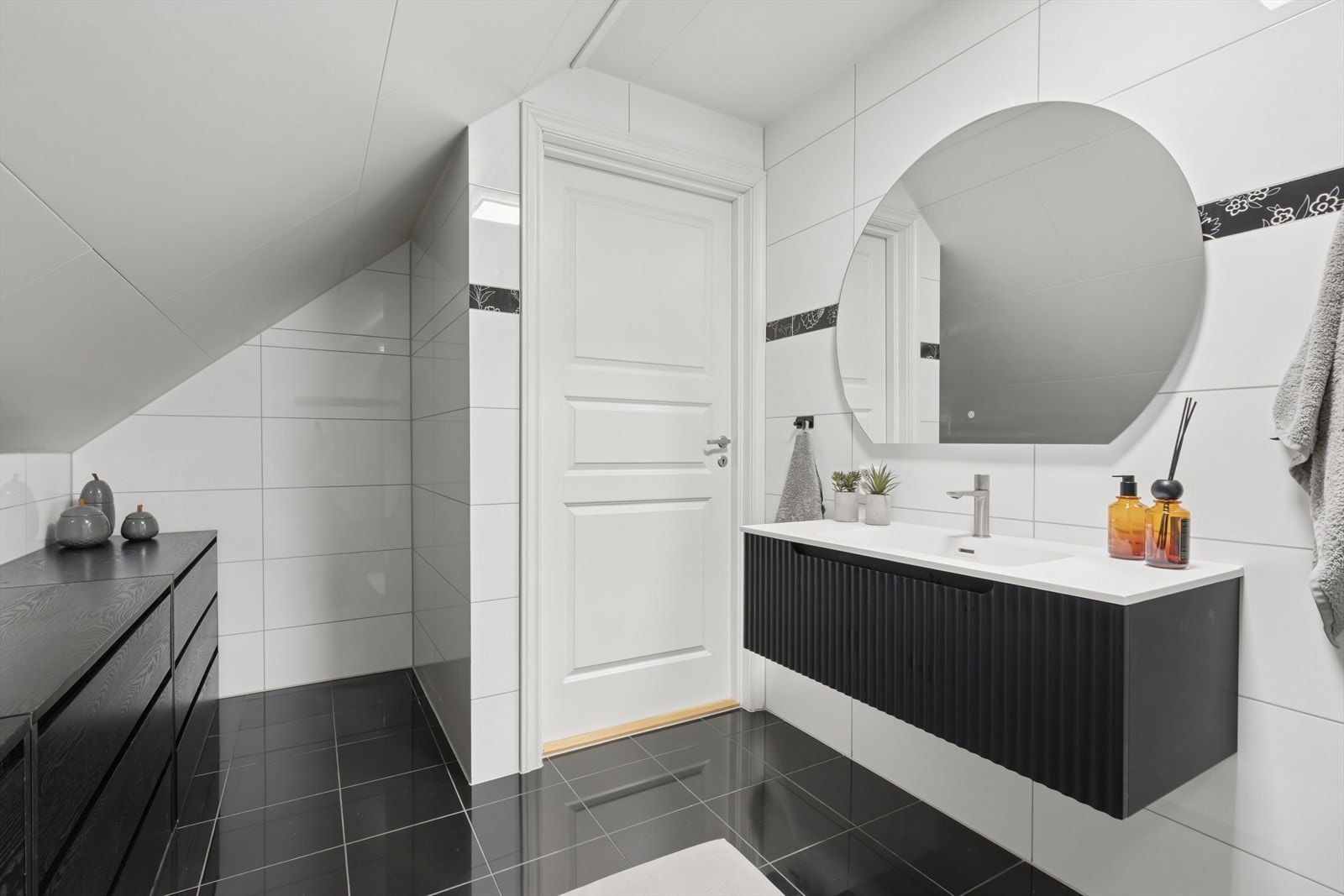 Badet er utstyrt med toalett, dusjhjørne med glassvegger, samt innredning med nedfelt servant og speil. Galleribilde