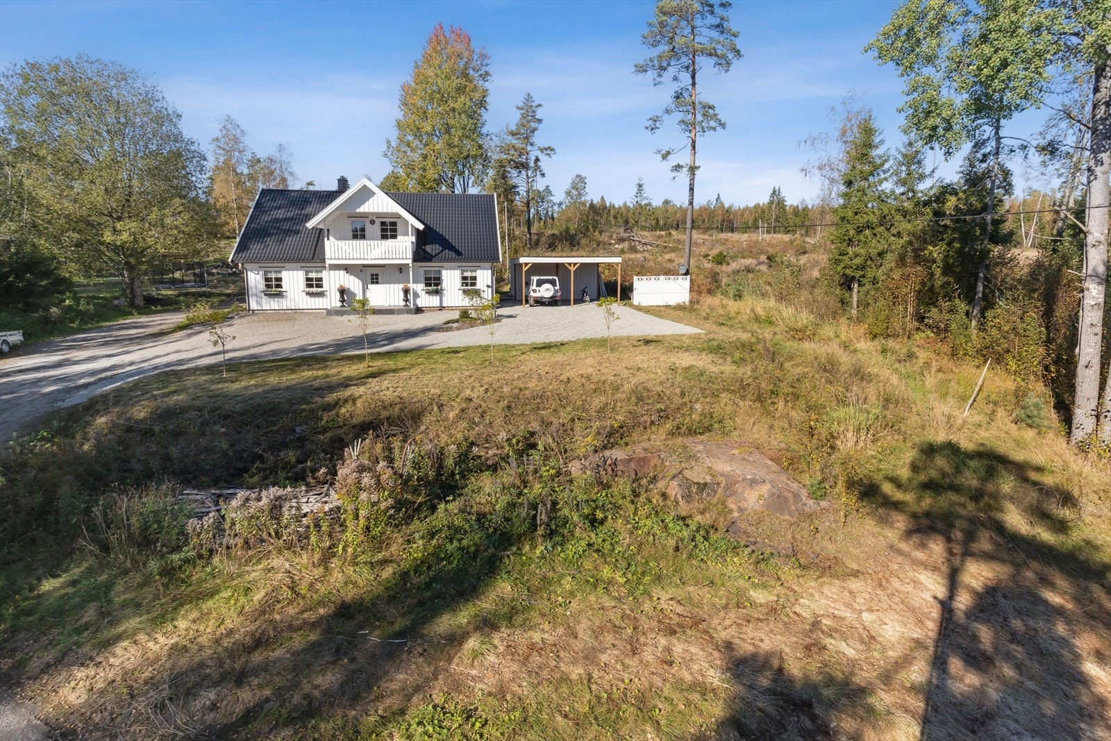 Lettstelt tomt som er opparbeidet plenarealer, hekk, trær, diverse beplantning, naturtomt samt gruset gårdsplass. Galleribilde