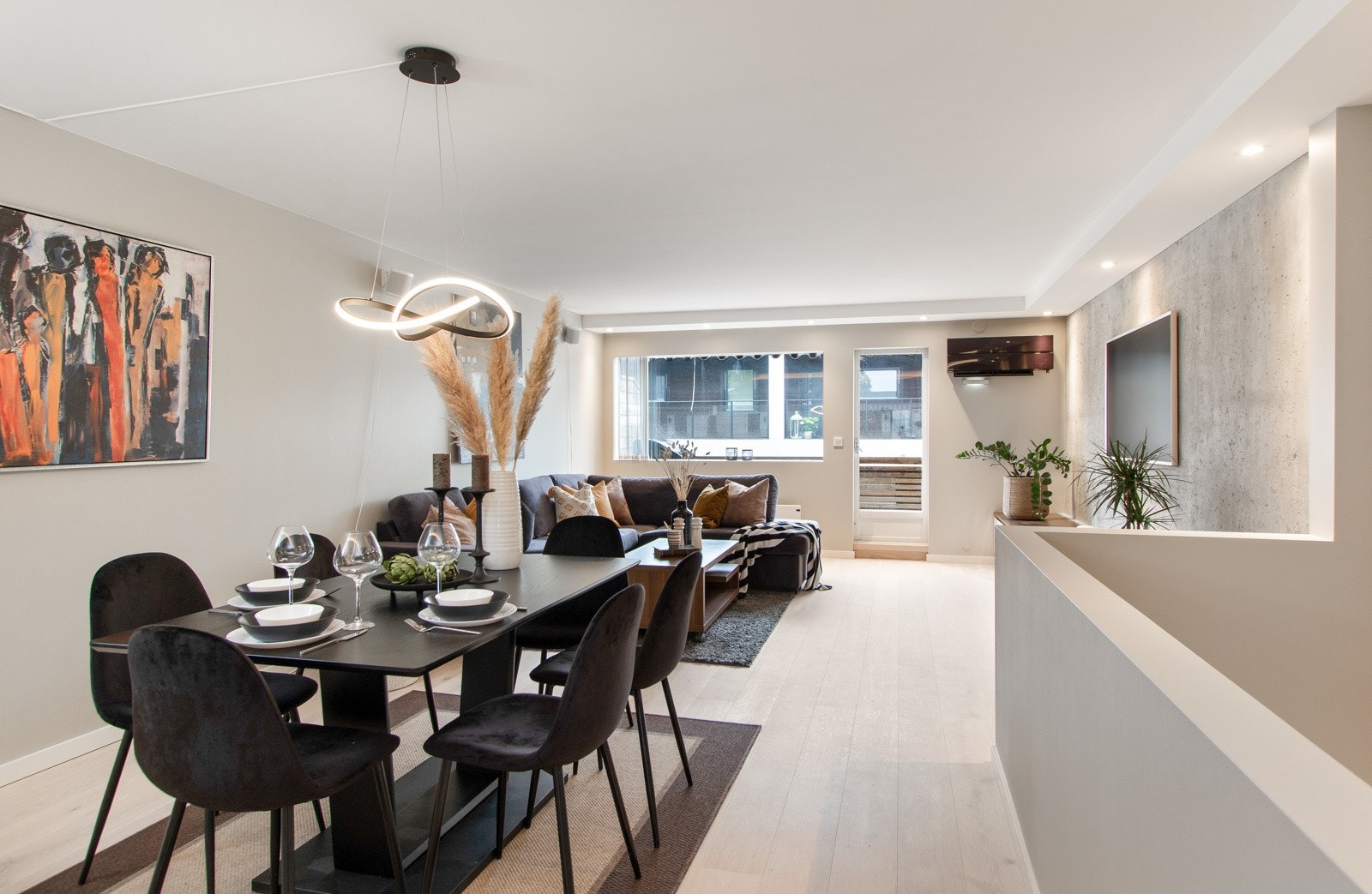 Rommet har lyst, enstavs parkettgulv fra Boen fra 2023, vegger malt i en lys beigetone, samt listefri, hvitmalt himling med downlights i kjøkkensonen og nedfelte downlights langs himlingen i stuesonen. Galleribilde