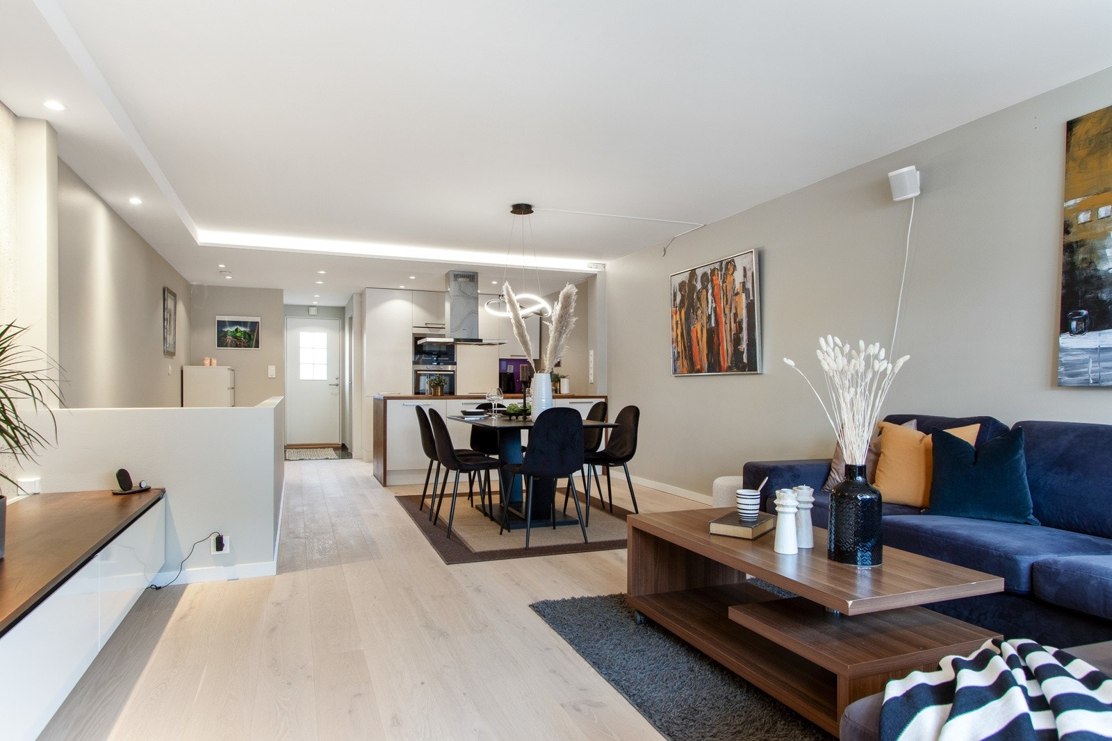 Stuen har god plass til både tv-lounge og spisebord, og på endeveggen er det montert en varmepumpe som sørger for jevn temperatur året gjennom. Galleribilde