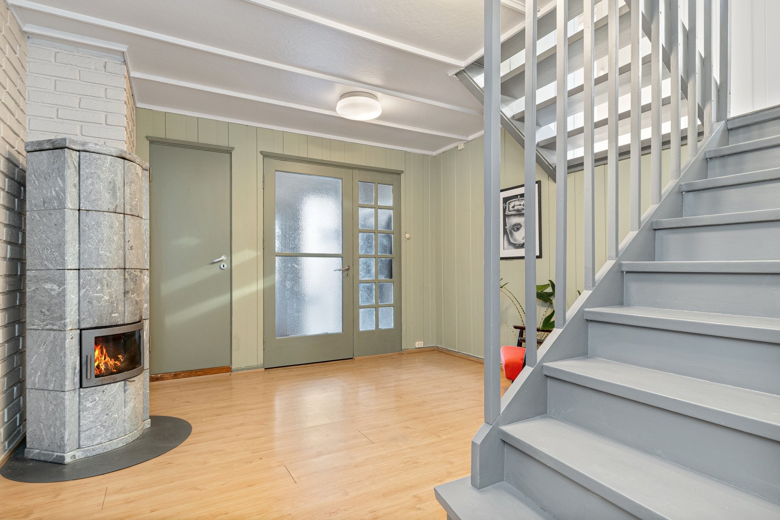 Hallen har peisovn for ekstra varme og hygge. Vindfanget ligger i tilknytning til en gang med to boder, perfekte for oppbevaring av yttertøy og diverse utstyr. Galleribilde