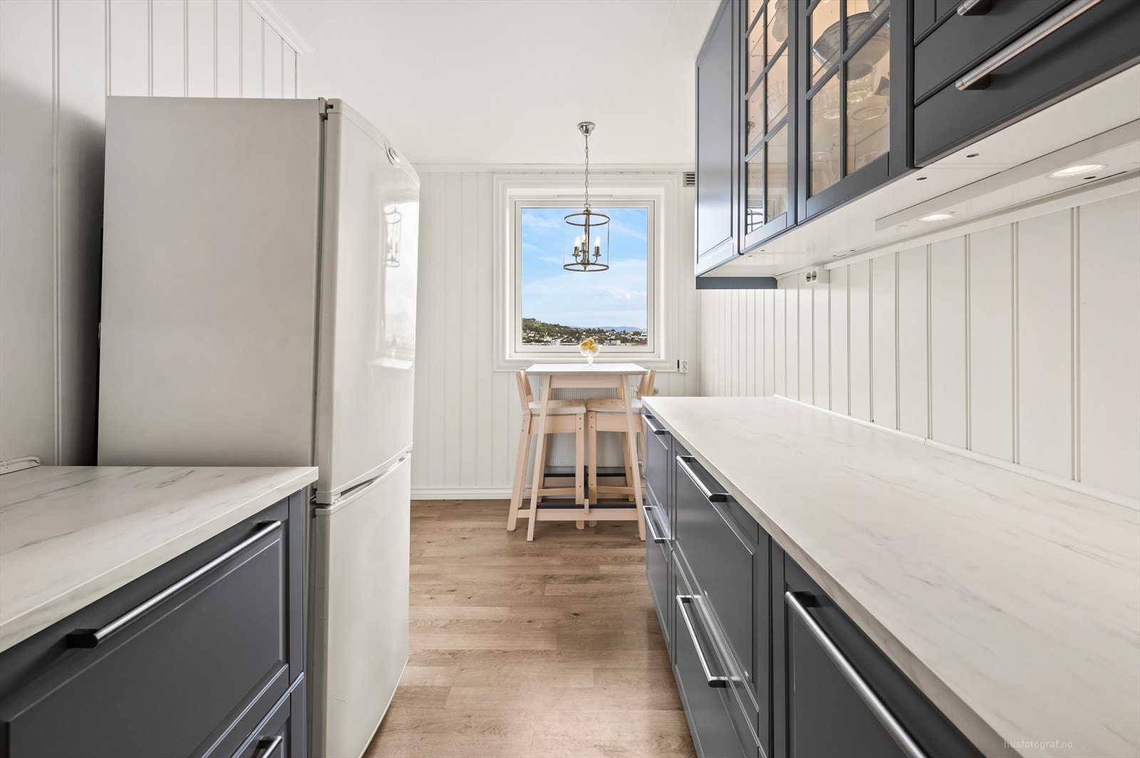 Klassisk kjøkkeninnredning med grå profilerte fronter og benkeplate av laminat fra IKEA. Galleribilde