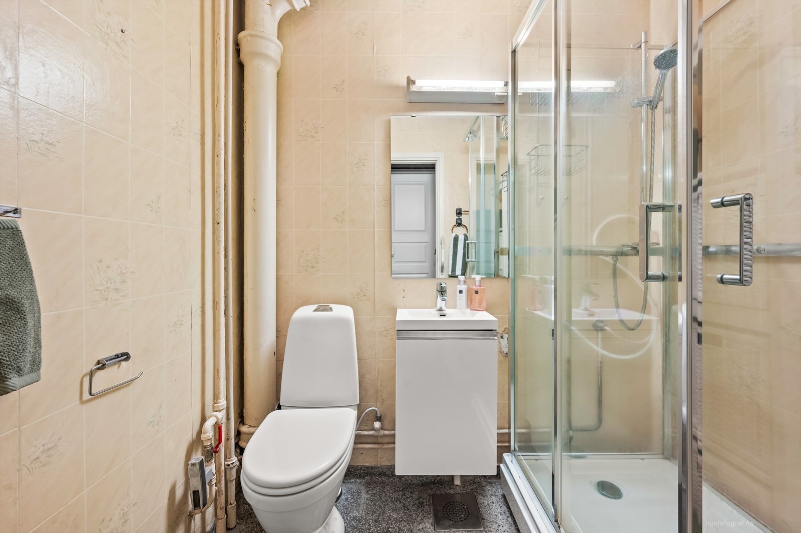 Badet er innredet med servant med rom for oppbevaring i underskap, speil, toalett og dusjkabinett. Felles vaskerom i byggets kjelleretasje. Galleribilde