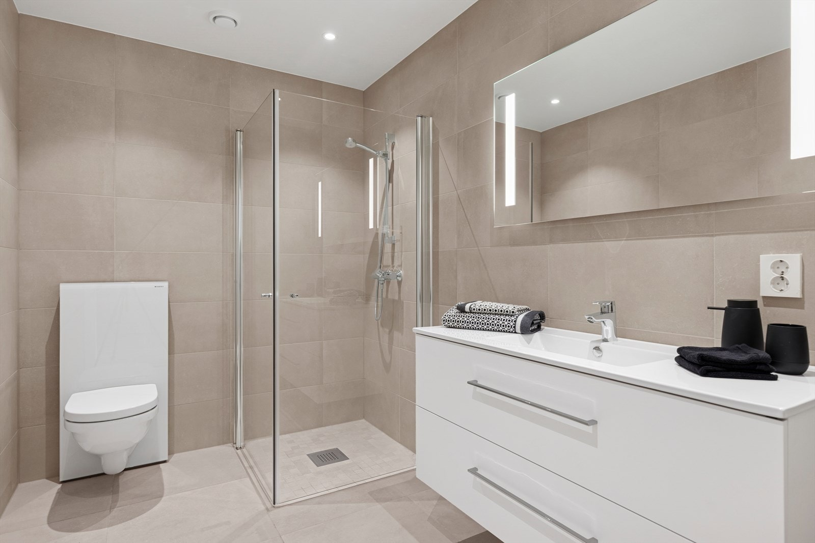 Baderommet har smakfull innredning og store eksklusive fliser på gulv og vegger, samt mosaikk i dusjen. Galleribilde