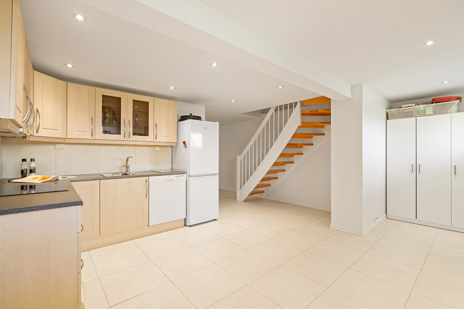 Lekkert kjøkken med lyse fronter og mørk benkeplate som skaper en moderne uttrykk. Galleribilde