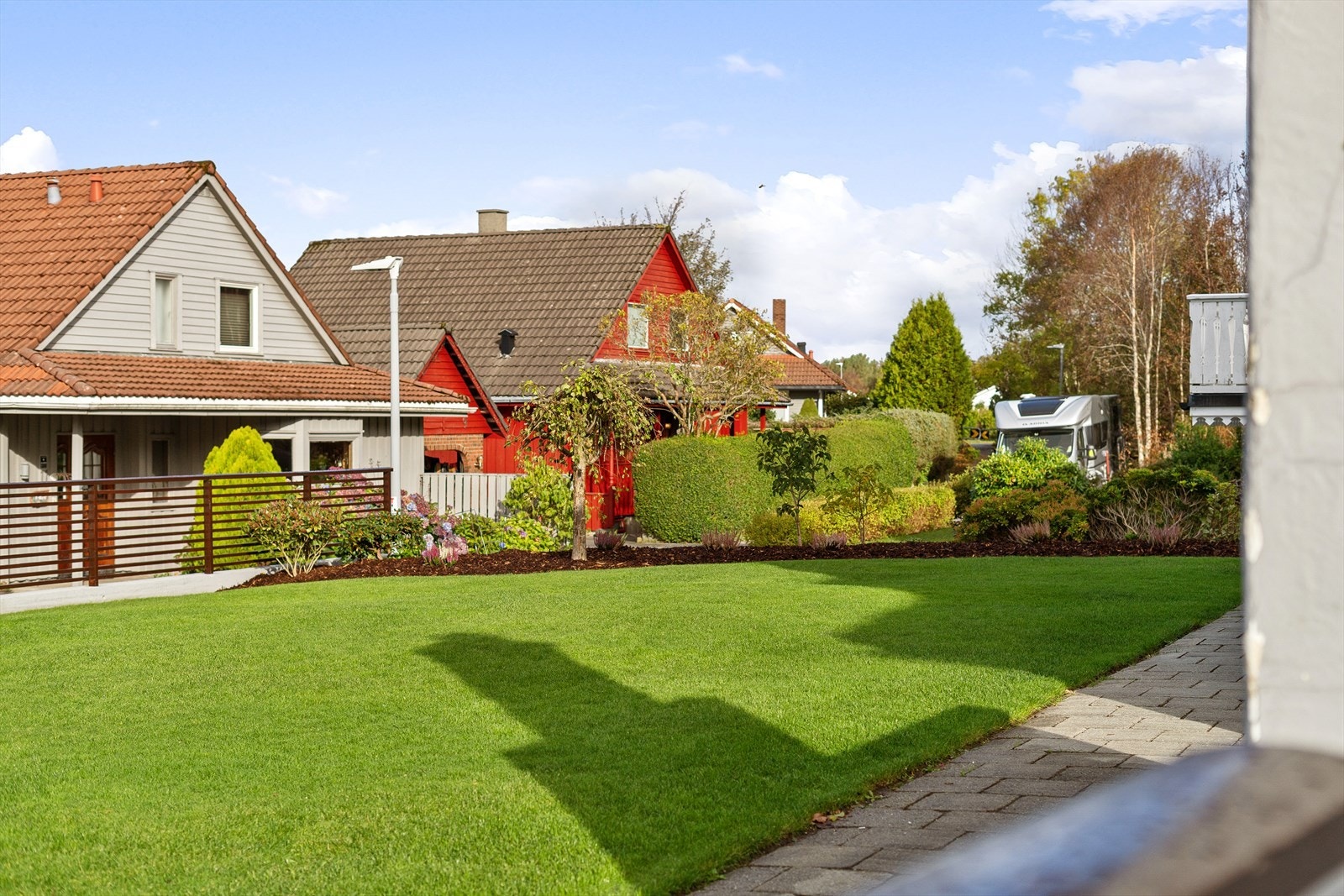 Solrik tomt opparbeidet med plen, busker trær og annen flott beplantning. Uteområde er enkelt å vedlikeholde. Galleribilde