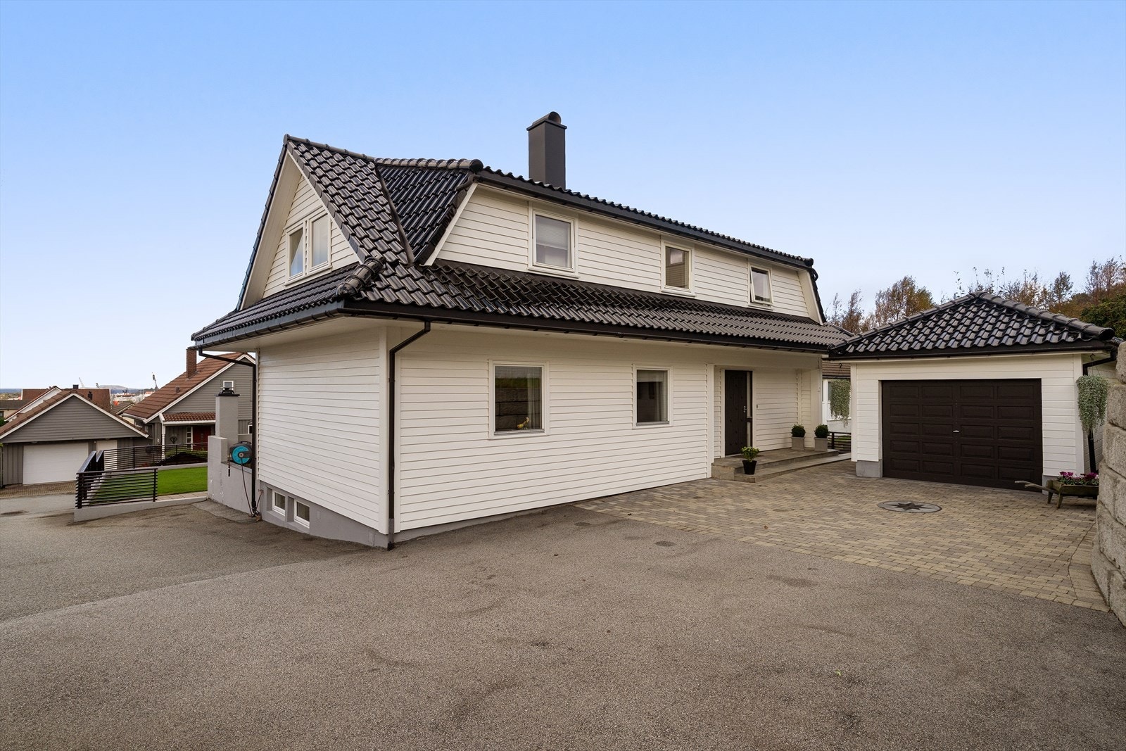 Lekkert opparbeidet gårdsrom med belegningsstein og gode parkeringsmuligheter i garasje samt på tomt. Galleribilde