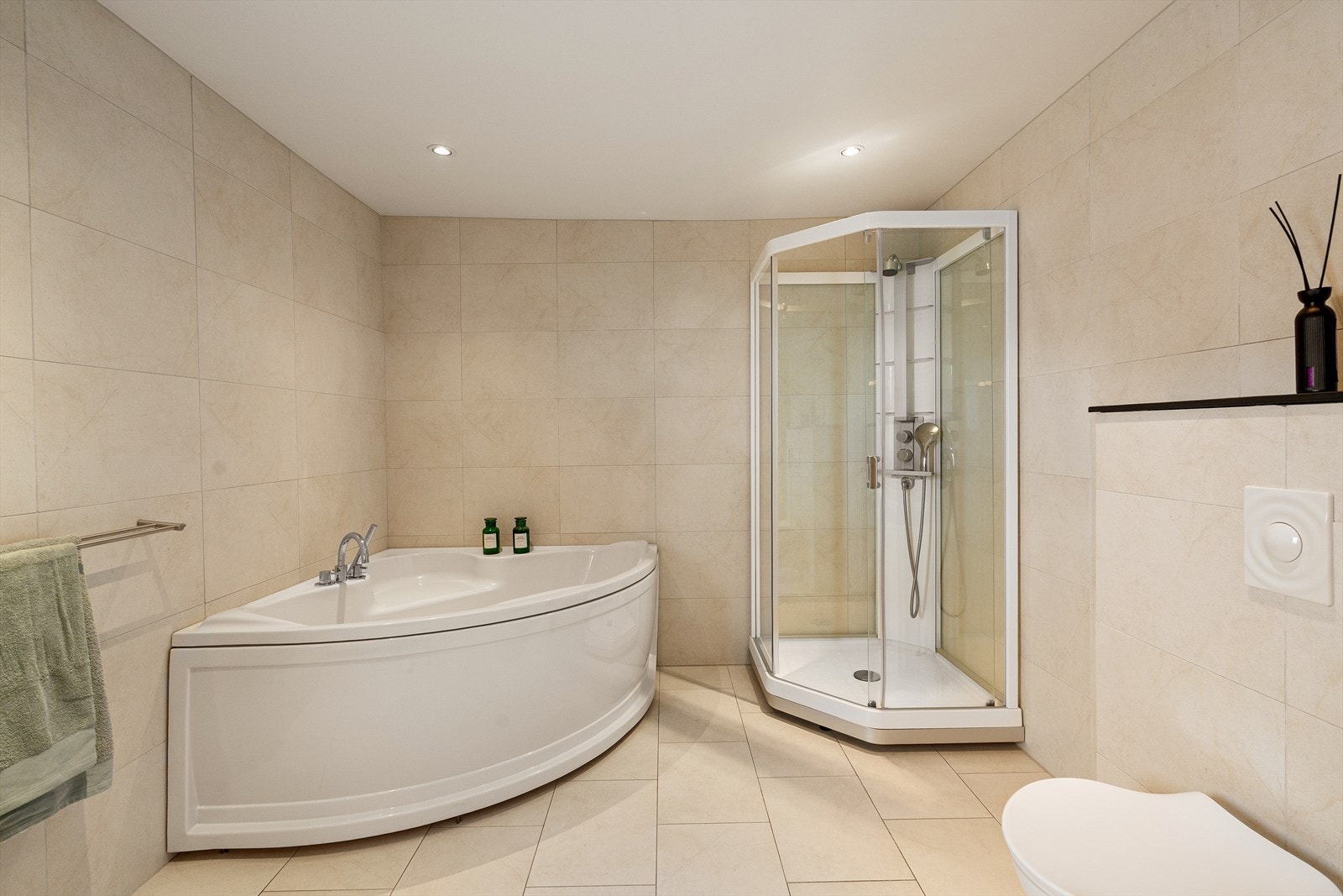 Badet er utstyrt med servant, hjørnebad, dusjkabinett og vegghengt toalett. Galleribilde