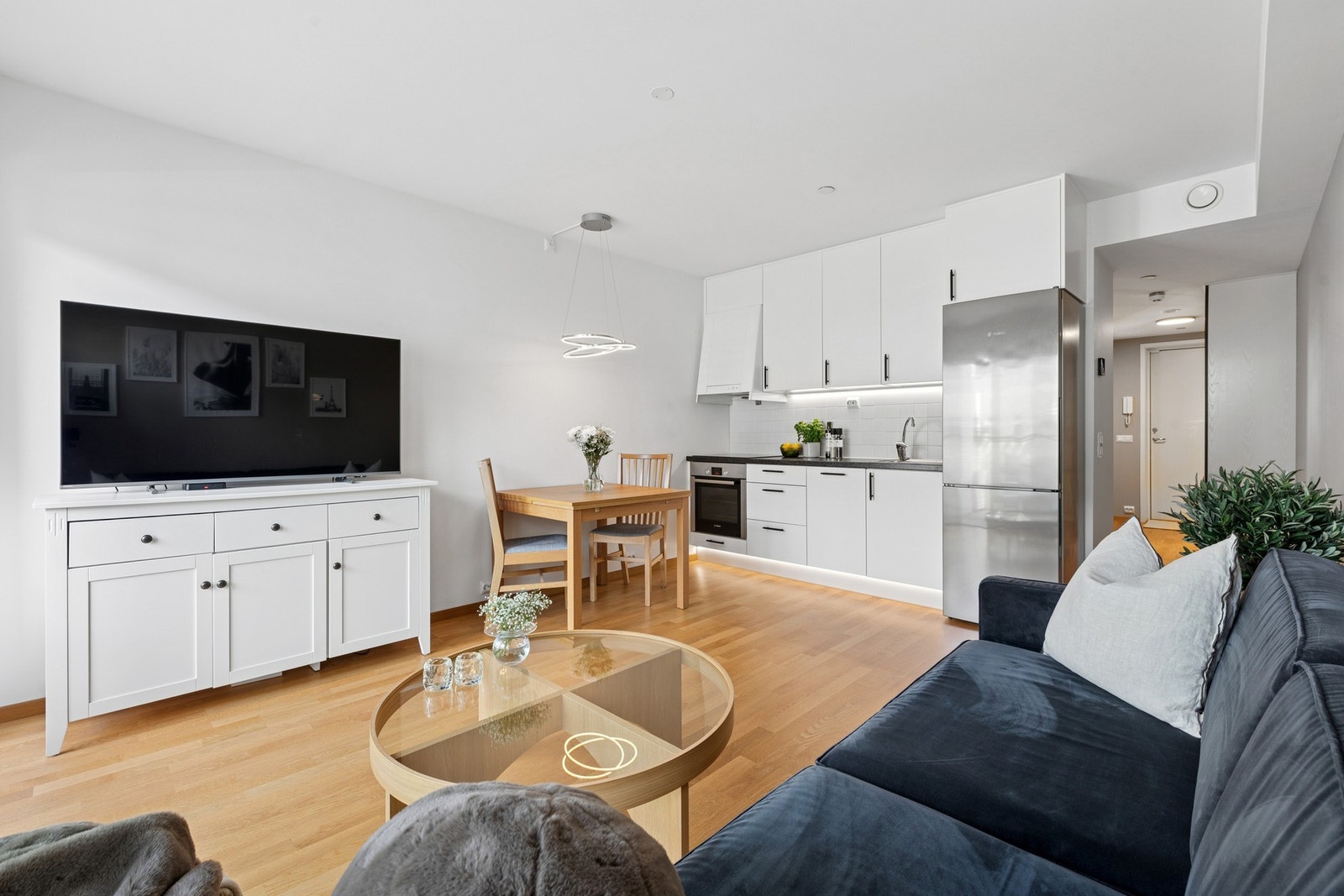 Allrommet er holdt i en stilren kombinasjon med lysmalte overflater mot gyllent parkettgulv. Galleribilde