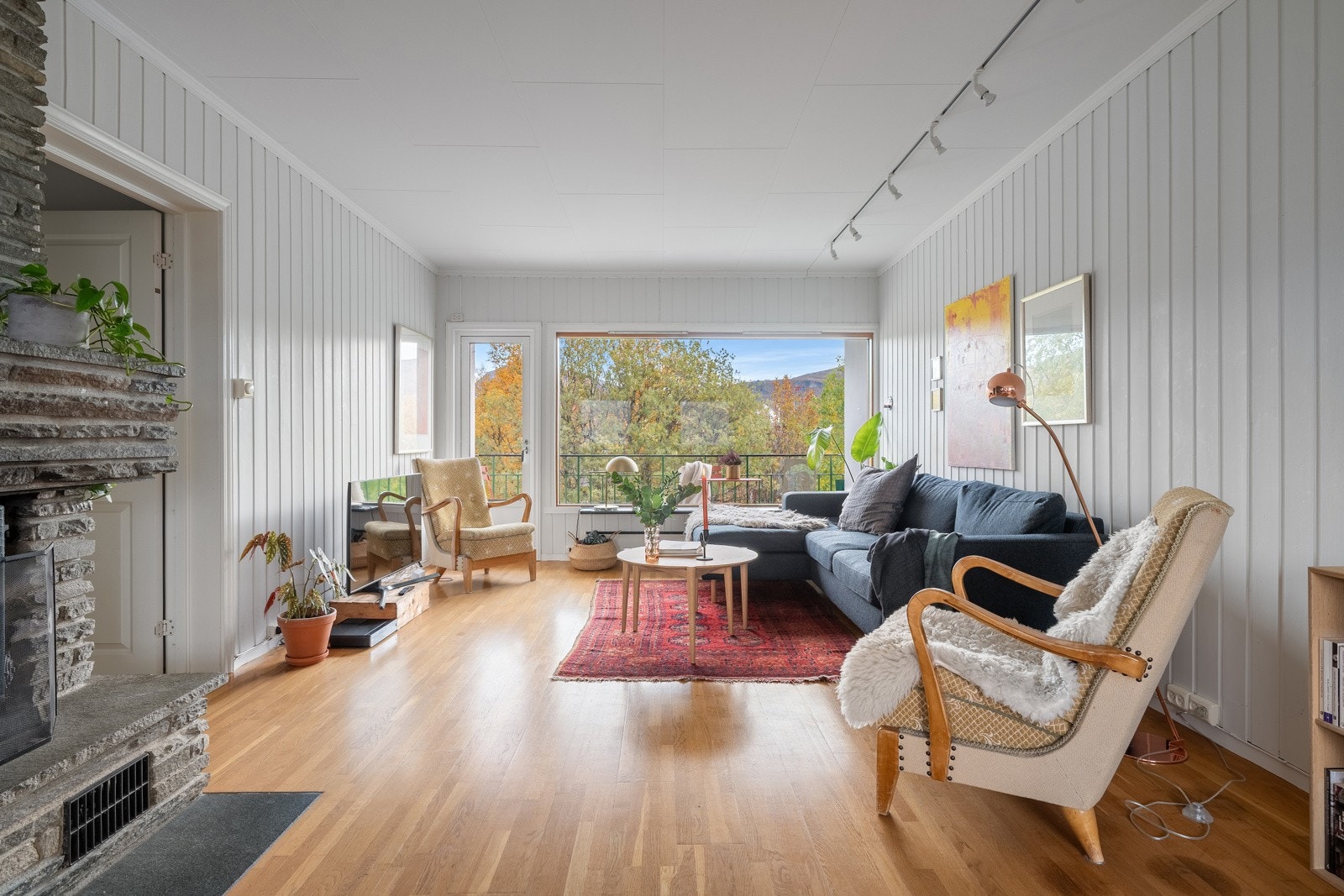 Stuen framstår innbydende med lyse farger, god takhøyde og store vindusflater.