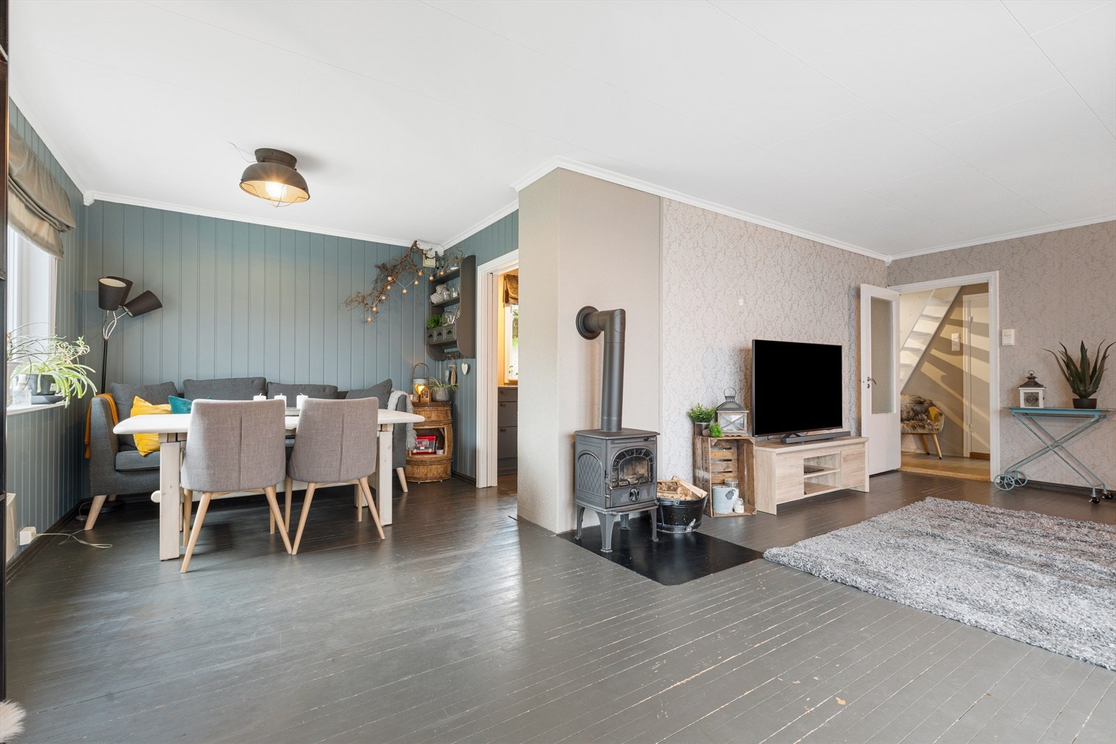 En åpen og lys stue med peis som varmer godt på kjølige dager Galleribilde