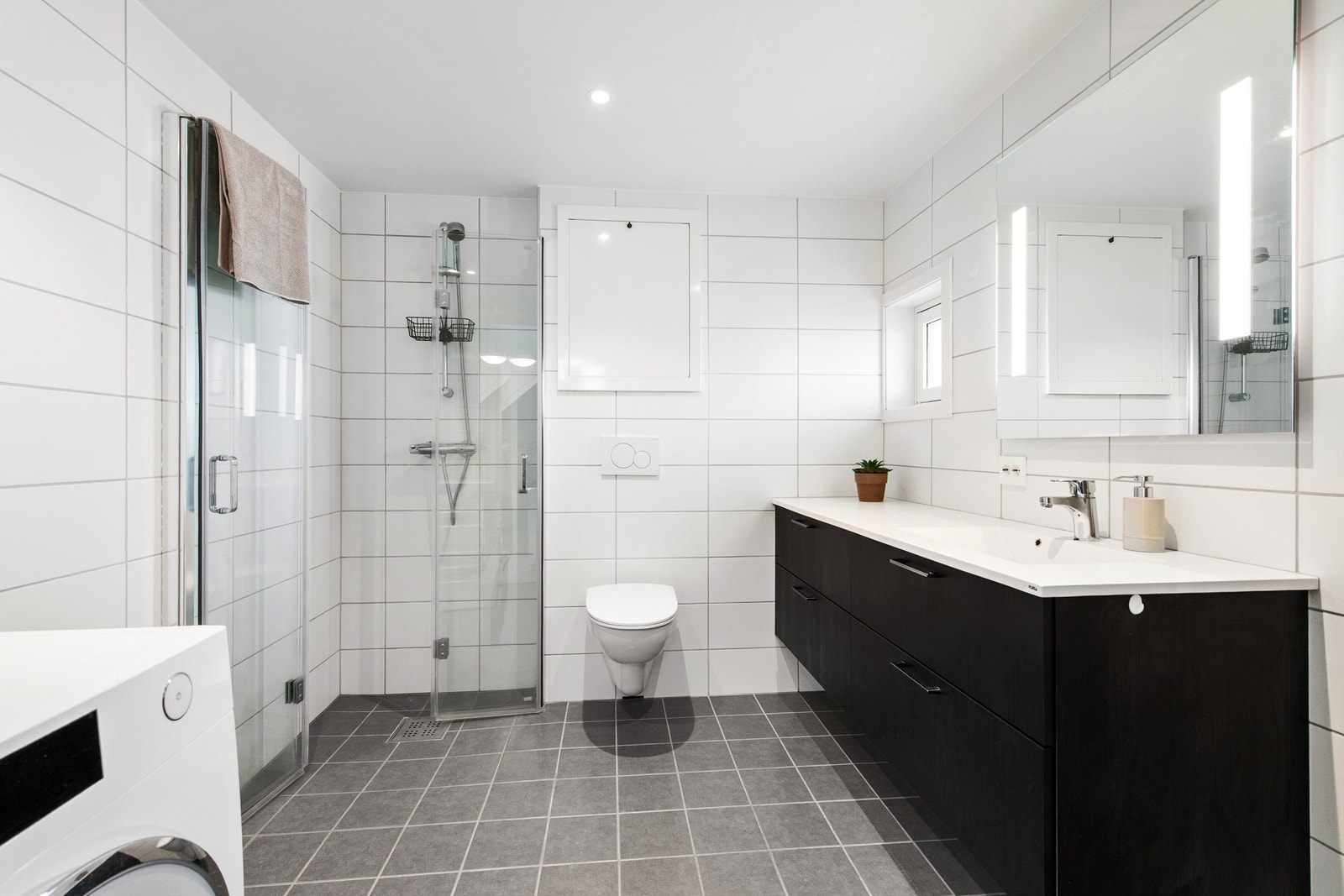 Flott flislagt bad med med innredning, dusjhjørne og wc. Galleribilde