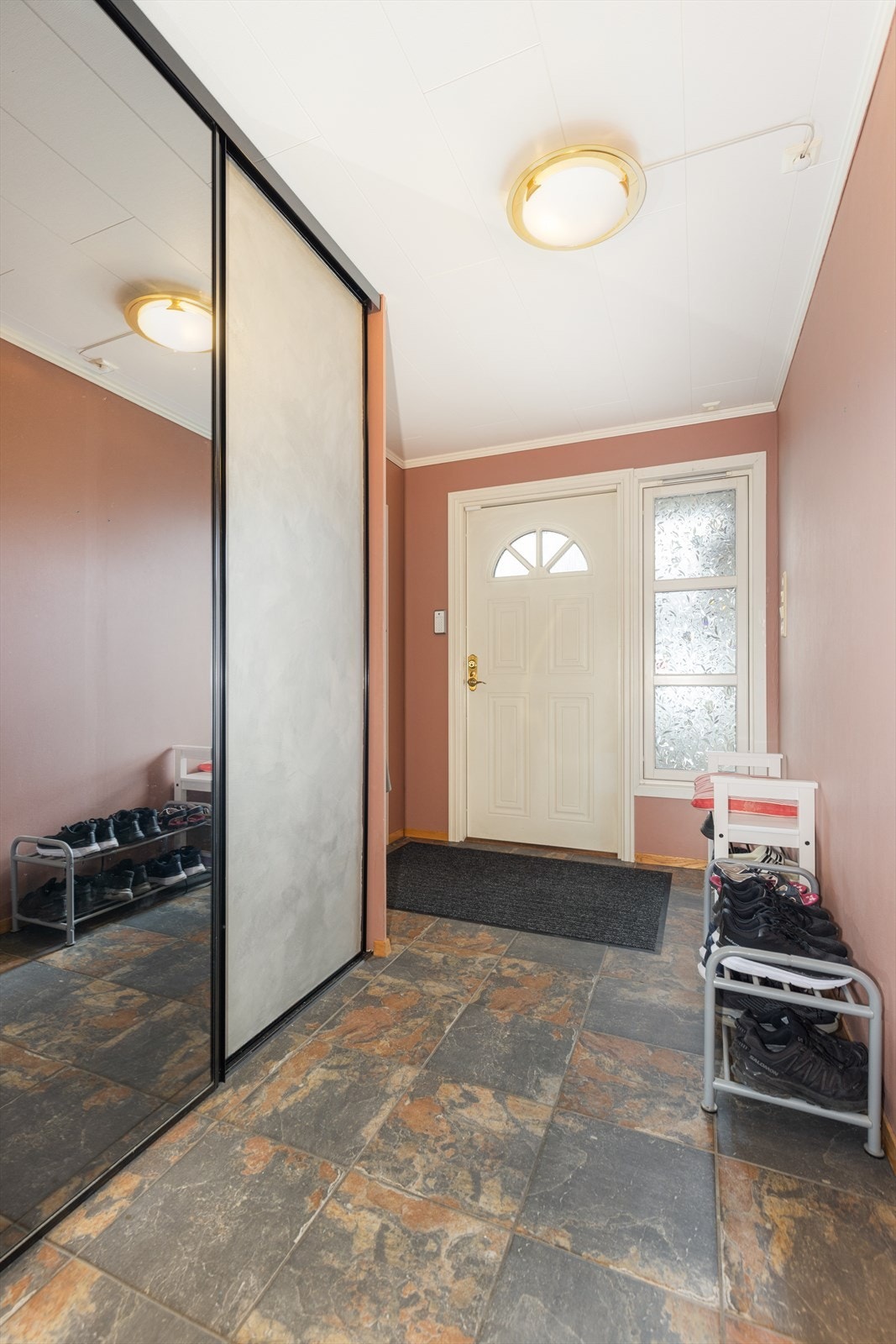 Velkommen inn i hyggelig entré med god plass til yttertøy i romslig skyvedørsgarderobe. Fra entré er det dør direkte inn til tilliggende garasje. Folie på rutene kan enkelt fjernes dersom ønskelig. Galleribilde