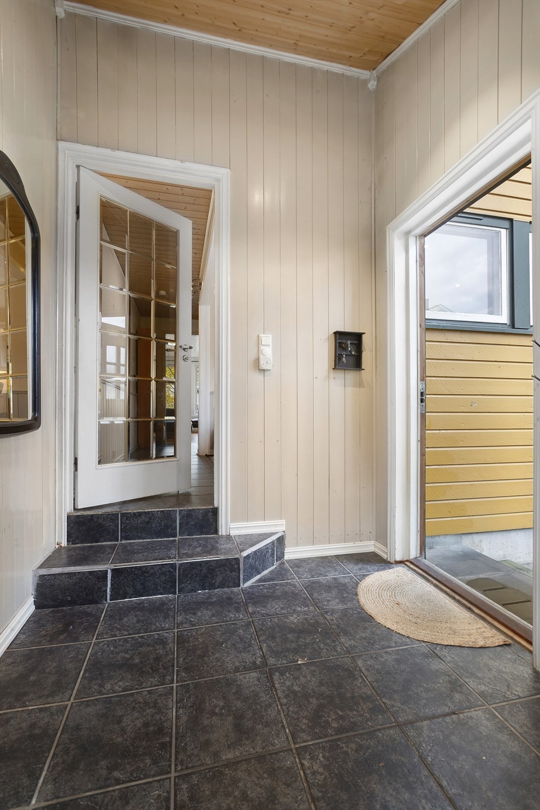 Man kommer inn i en romslig entré med fliser på gulv og gulvvarme Galleribilde