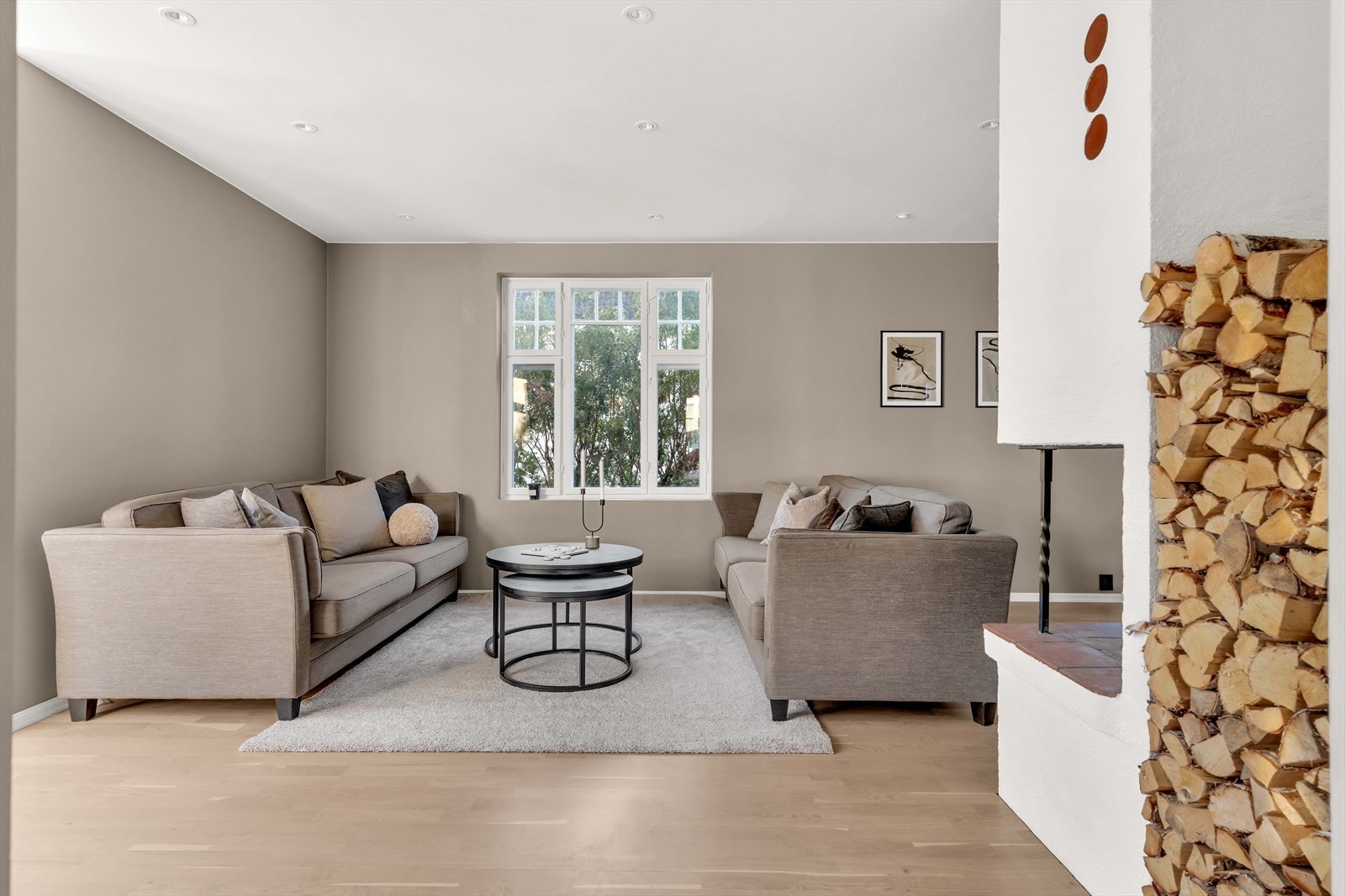 Stuen er pen og romslig, med store vindusflater som slipper inn rikelig med dagslys, samtidig som den bringer noe av det grønne inn i rommet. Galleribilde