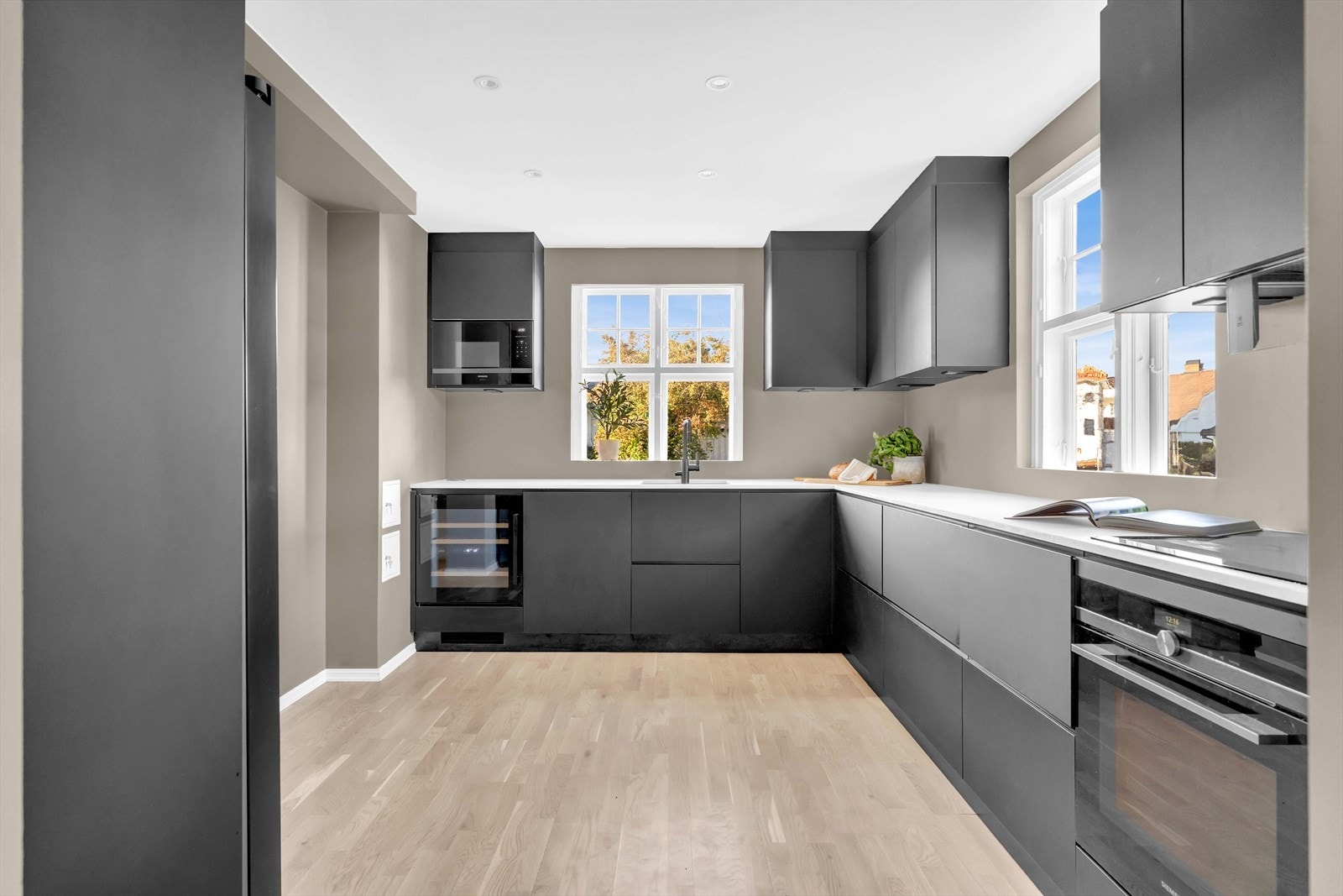 Her får du lange benkeplater og samtlige hvitevarer helintegrert, deriblant induksjonstopp, stekeovn og mikrobølgeovn. Galleribilde