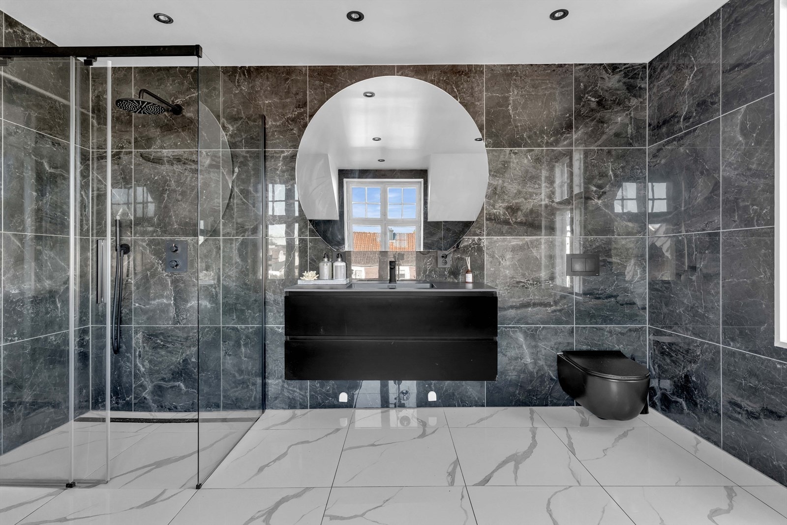 Baderomsinnredningen består av regnfallsdusj, badekar, servant, stort speil, vegghengt toalett, og opplegg for vaskemaskin. Galleribilde