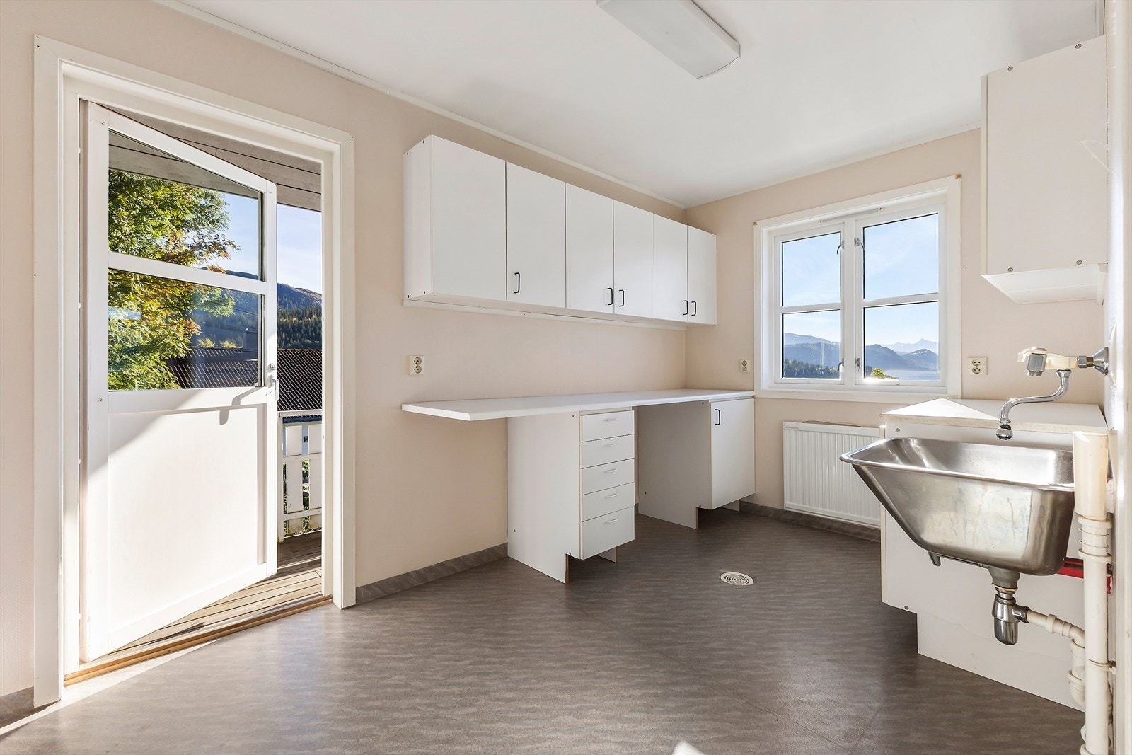 Her er det god plass til praktiske løsninger med oppvaskmaskin, tørketrommel, oppbevaring og arbeidsbenk. I tillegg er det utgang til balkongen. Galleribilde