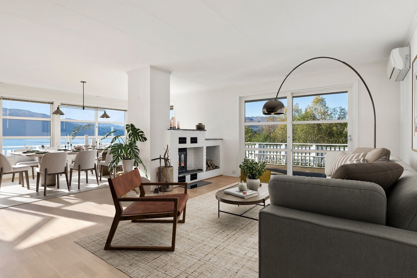 Moderne stue med peis og store vinduer som slipper inn rikelig med dagslys. Med et så romslig allrom er det særs gode møbleringsmuligheter. (Digitalt stylet) Galleribilde