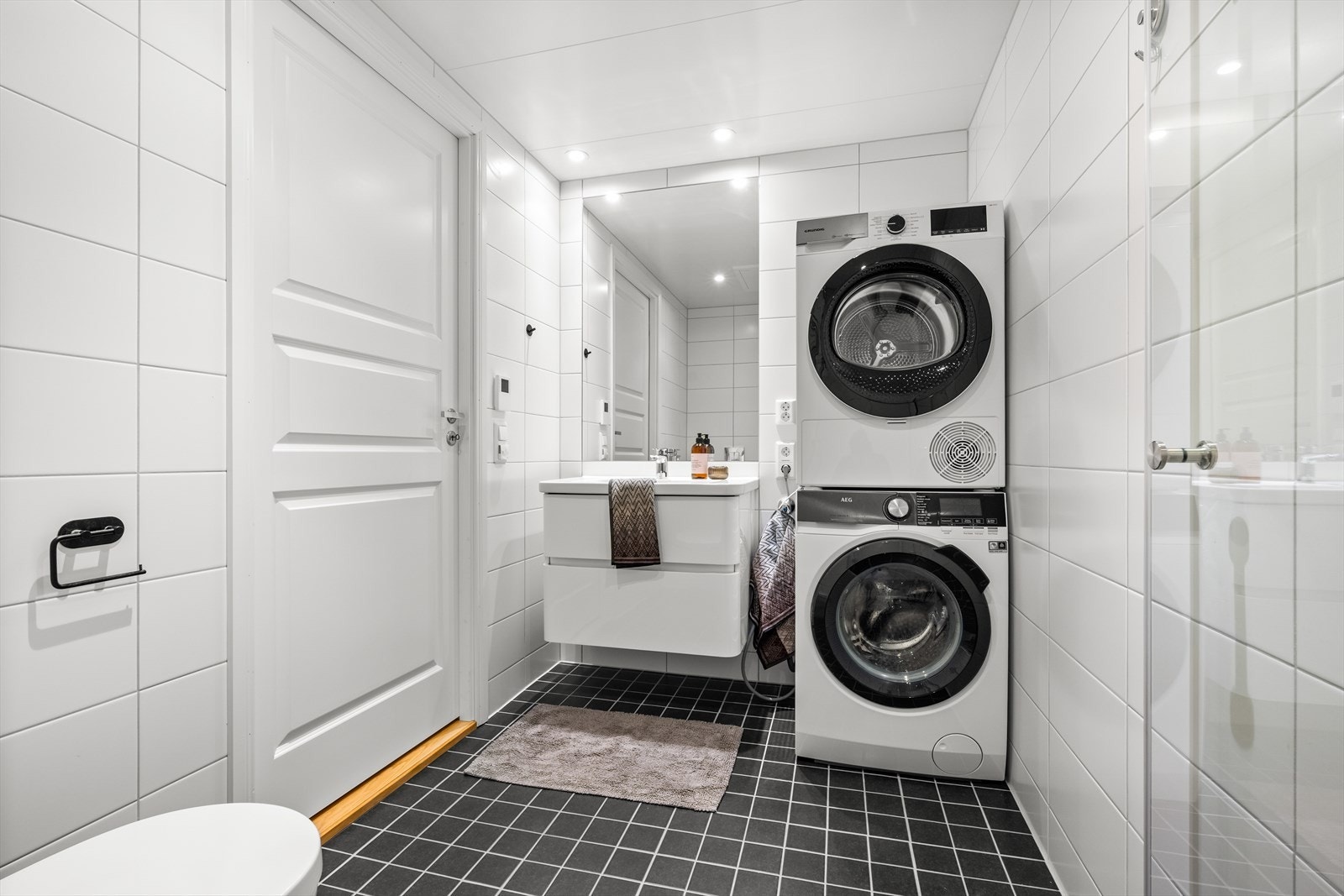 Flislagt bad med servant i innredningen. Opplegg til vask og tørk. Galleribilde