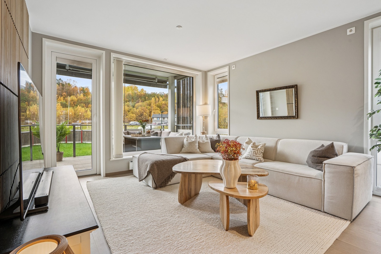 Store vindusflater i stuen skaper en luftig og lys atmosfære. Galleribilde