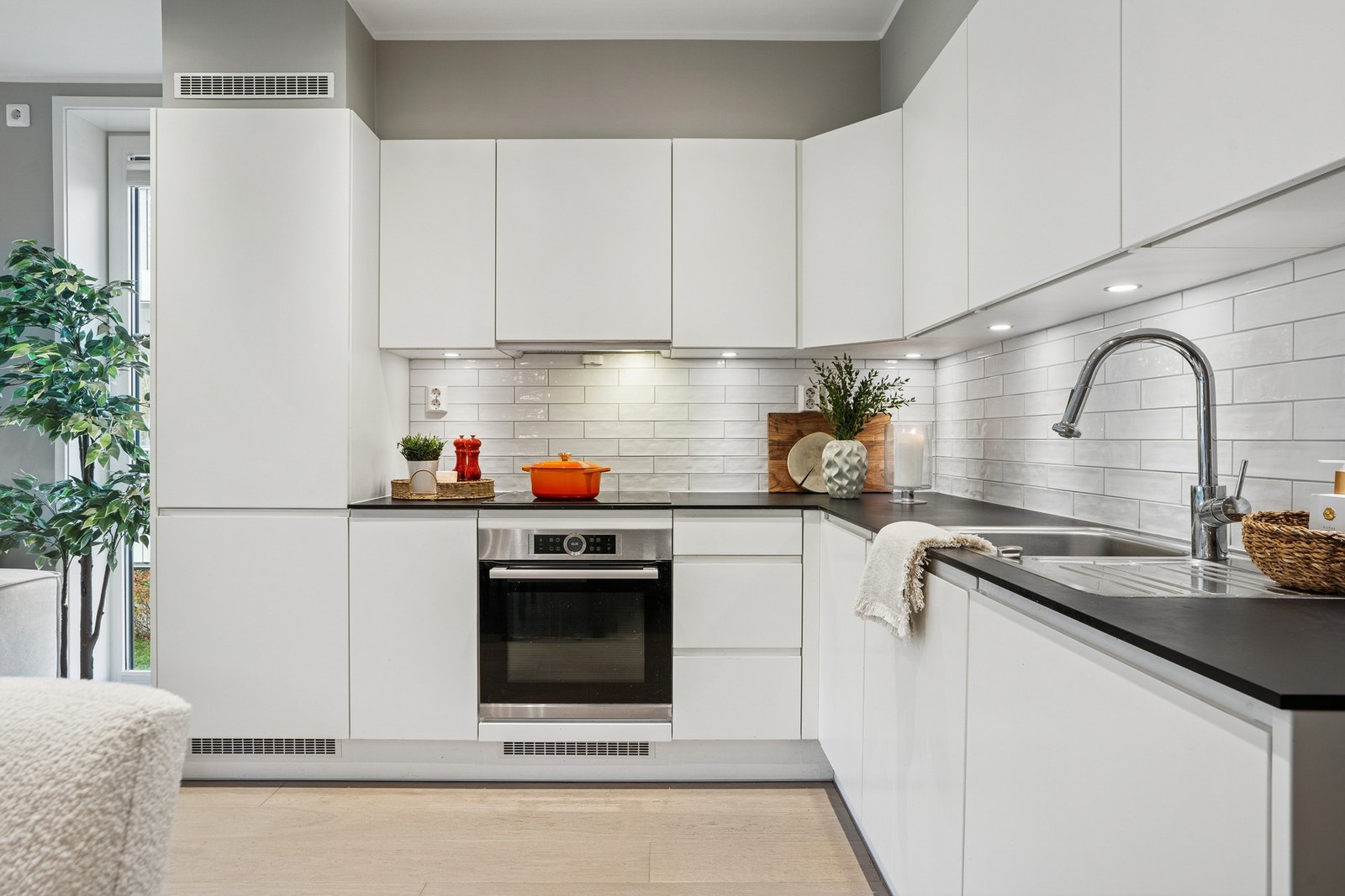 Moderne kjøkkeninnredning med slette fronter og laminert benkeplate. Kjøkkenet har integrerte hvitevarer. Galleribilde