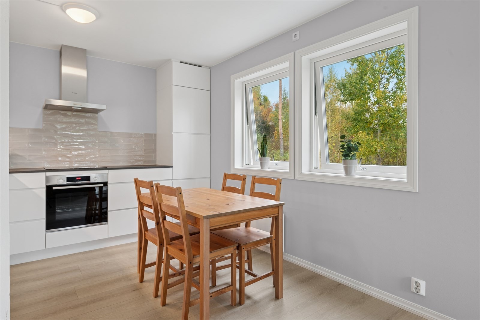 Pen kjøkkeninredning med hvite slette fronter. Galleribilde