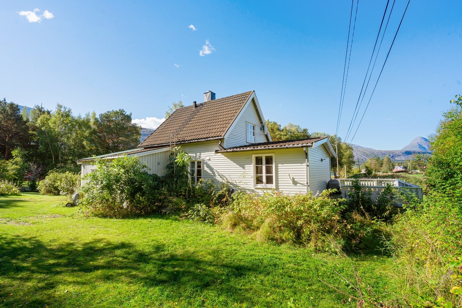 Sidefasade omgitt av grønn vegetasjon og frodig hage - eiendommen ligger fredelig til i Skjomen, men er lett tilgjengelig Galleribilde