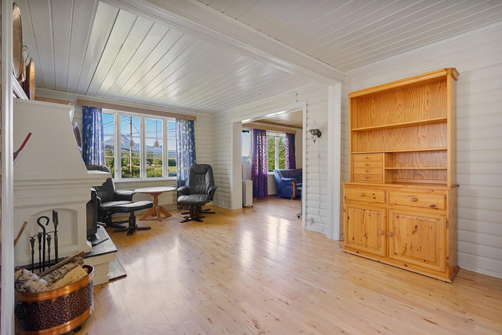 Stuen er utstyrt med store vinduer som gir mye naturlig lys og fin utsikt mot naturen utenfor Galleribilde