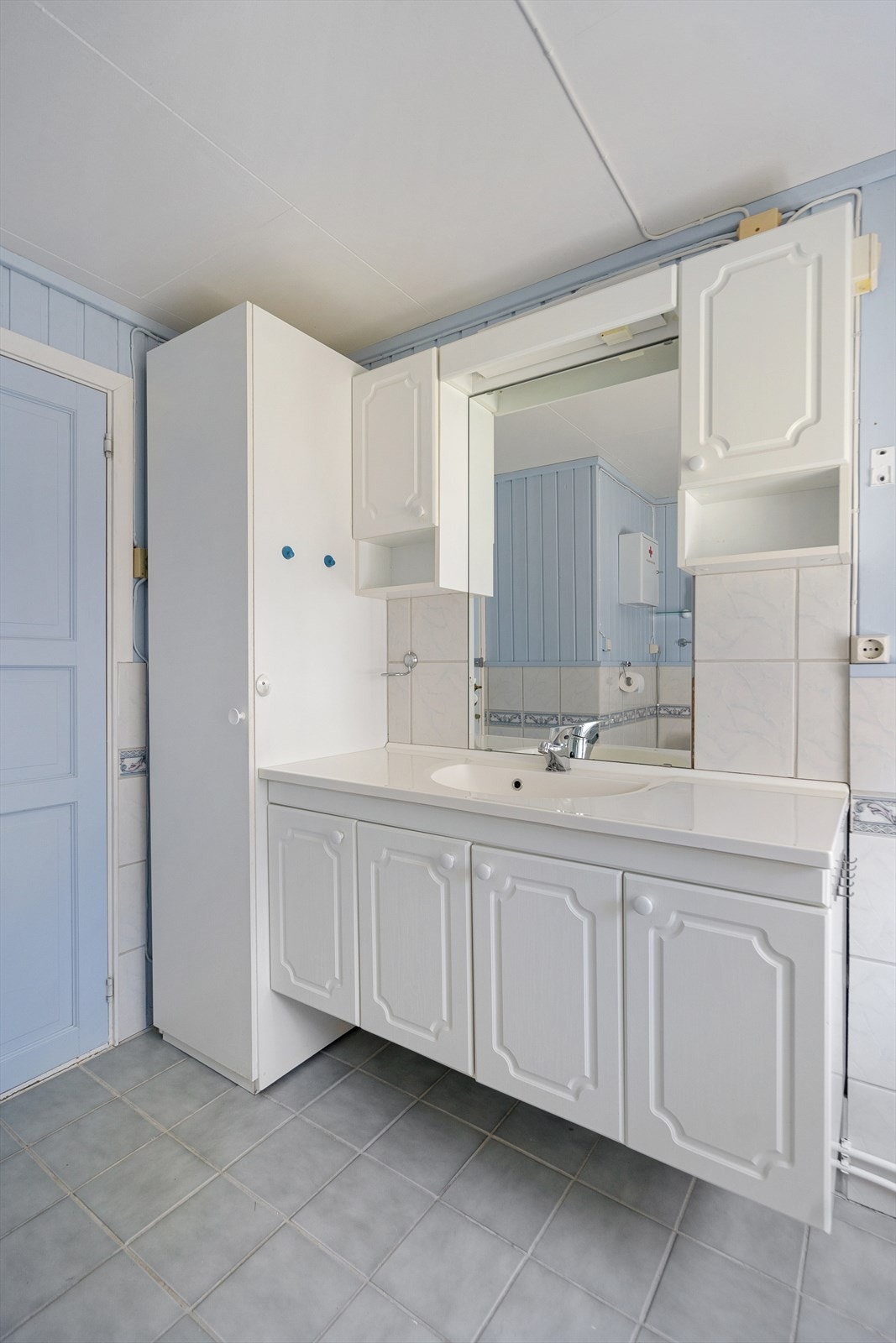 Lyst baderom med praktisk servantinnredning og godt med skapplass Galleribilde