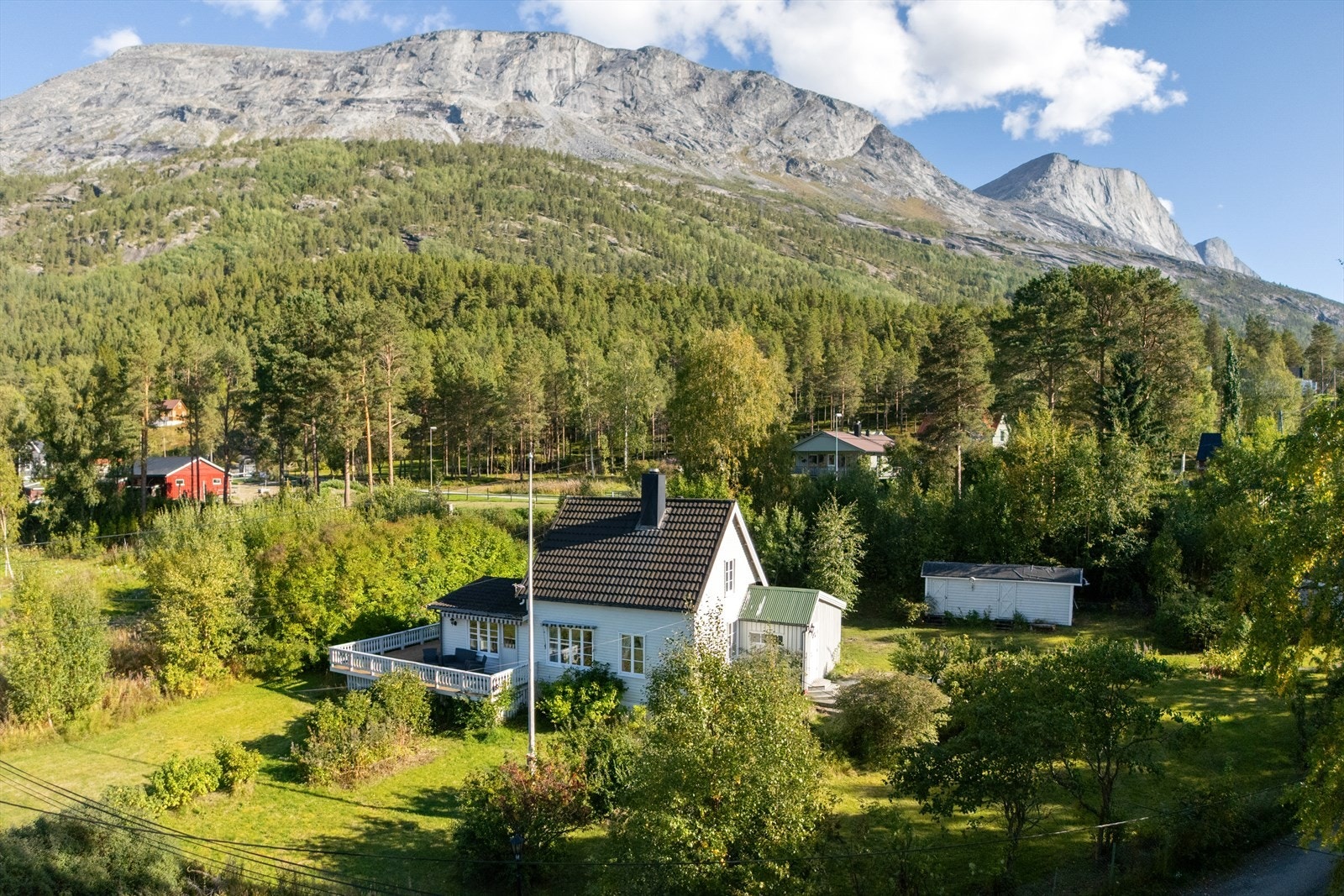 Luftfoto viser den romslige tomten, fritidsboligen og uteplassene. Naturen omkring gir både ro og utsikt Galleribilde