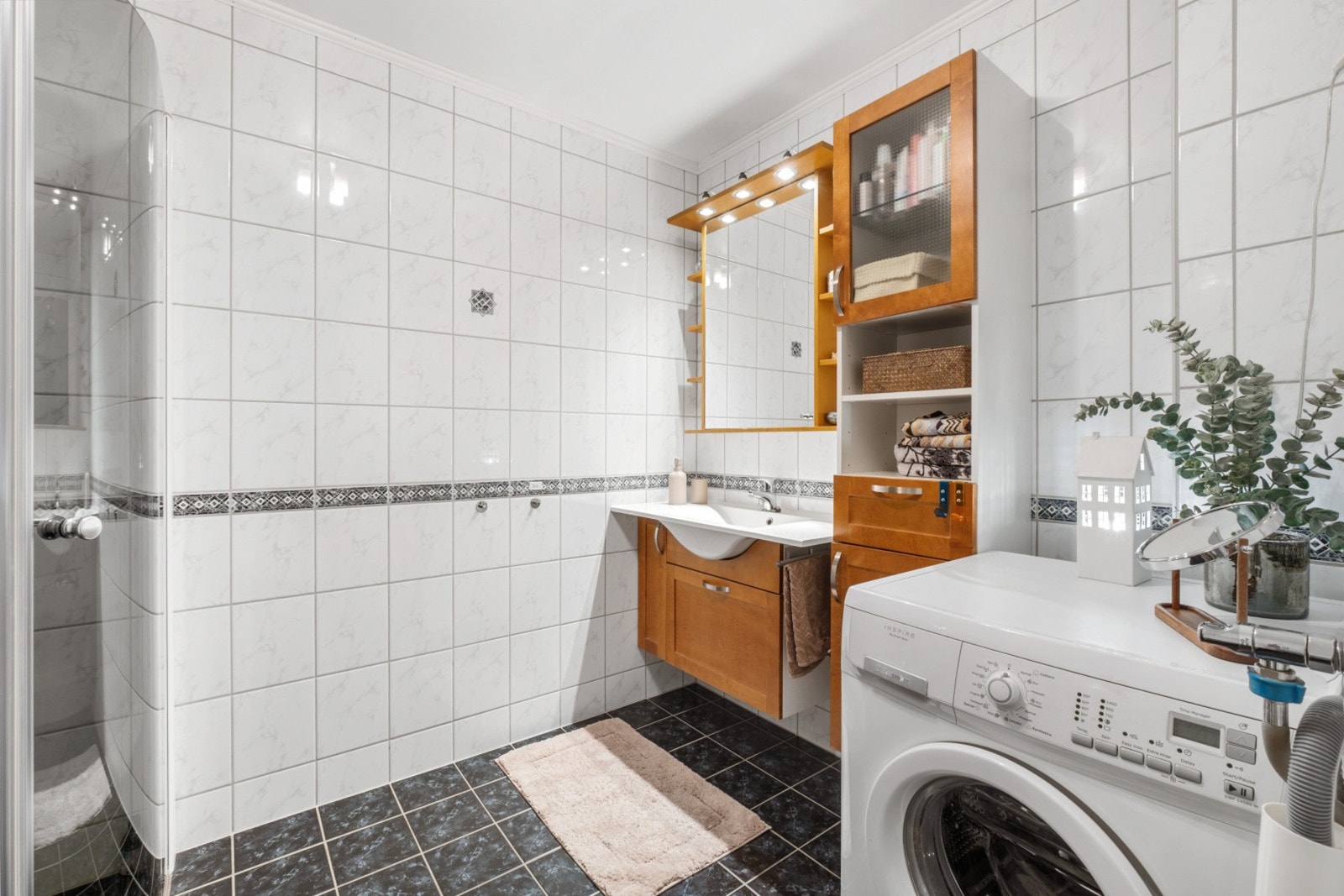 Badet har wc, dusjhjørne, romslig innredning og plass for vaskemaskin/tørketrommel. Galleribilde