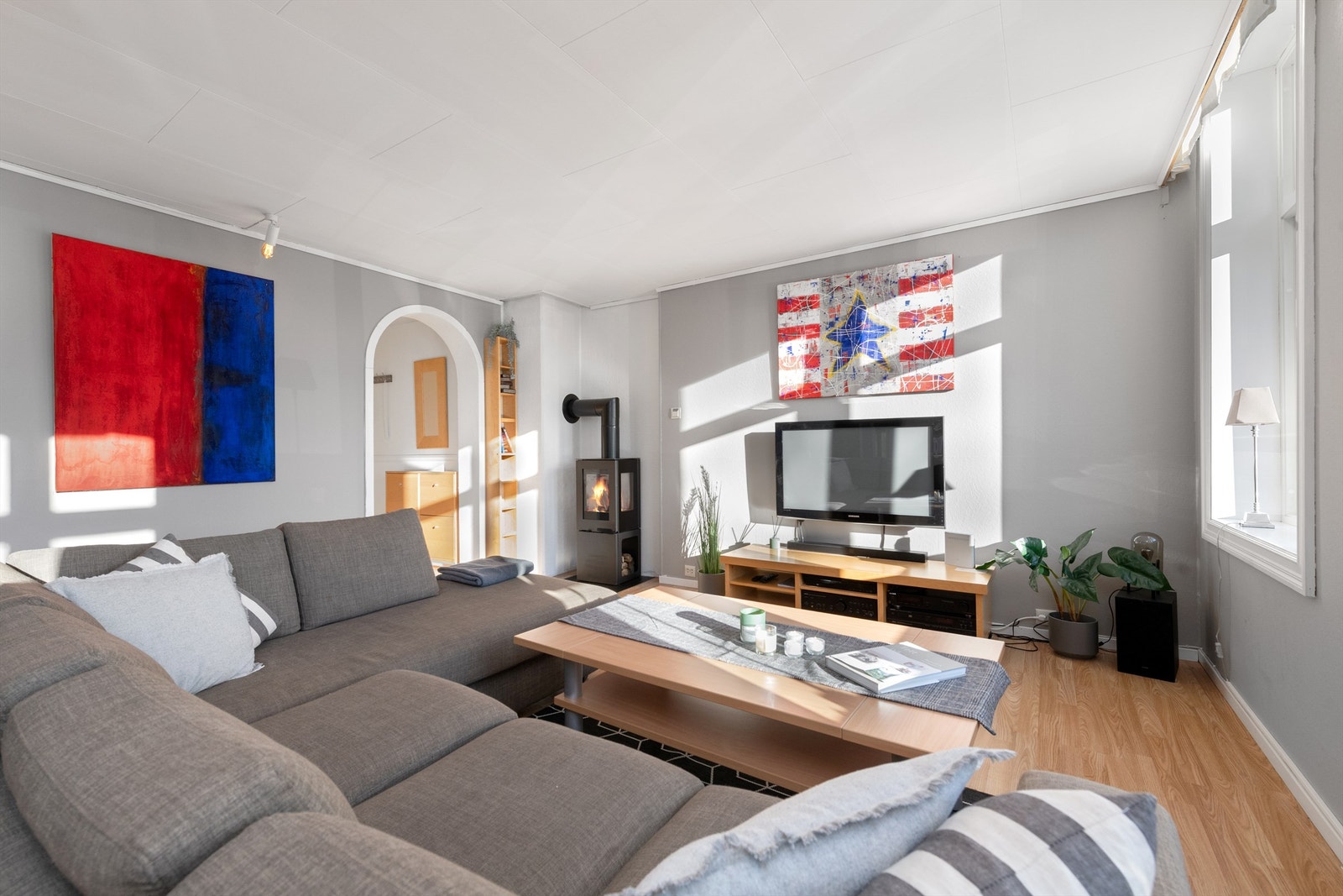 Peisovn med glassdør i stuen som gir en lun og hyggelig atmosfære Galleribilde