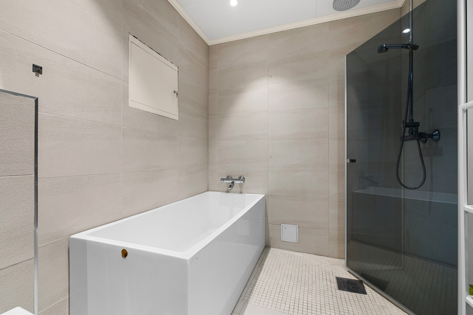 Badet er utstyrt med både badekar og dusjsone med innfellbare dusjdører. Galleribilde