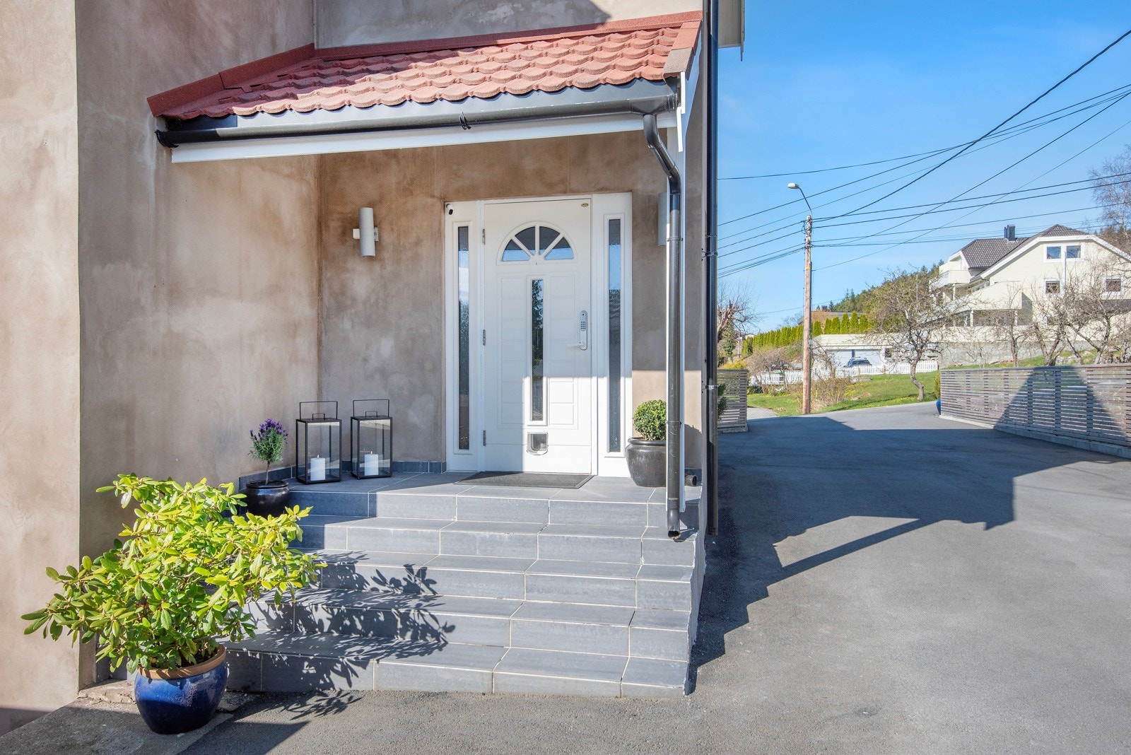 Pent overbygd inngangsparti med flislagt betongtrapp. Galleribilde