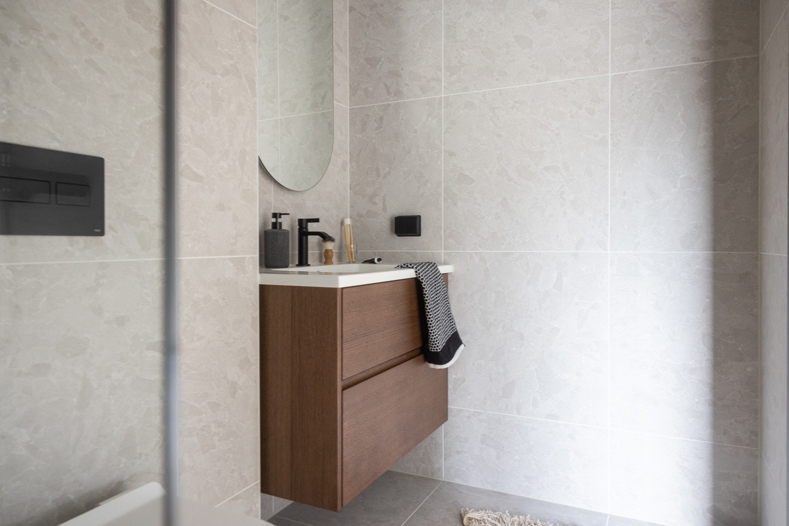 Det er innredet med beige-tonede fliser som gir et varmt og moderne preg. Her finner du dusjhjørne med regnfallsdusj, vegghengt toalett og servant med underskuffer. Galleribilde